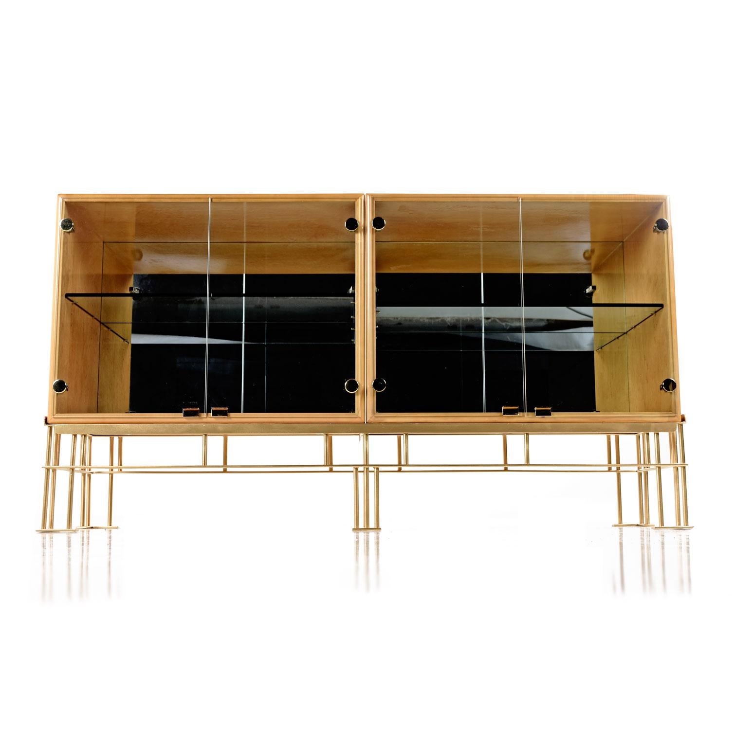 This Iridescent lacquered solid bird’s-eye maple credenza with it’s polished brass accents are sure to make this piece the focal point of any room. The two glass door cabinets features a mirrored back and adjustable glass shelf, allowing it to be