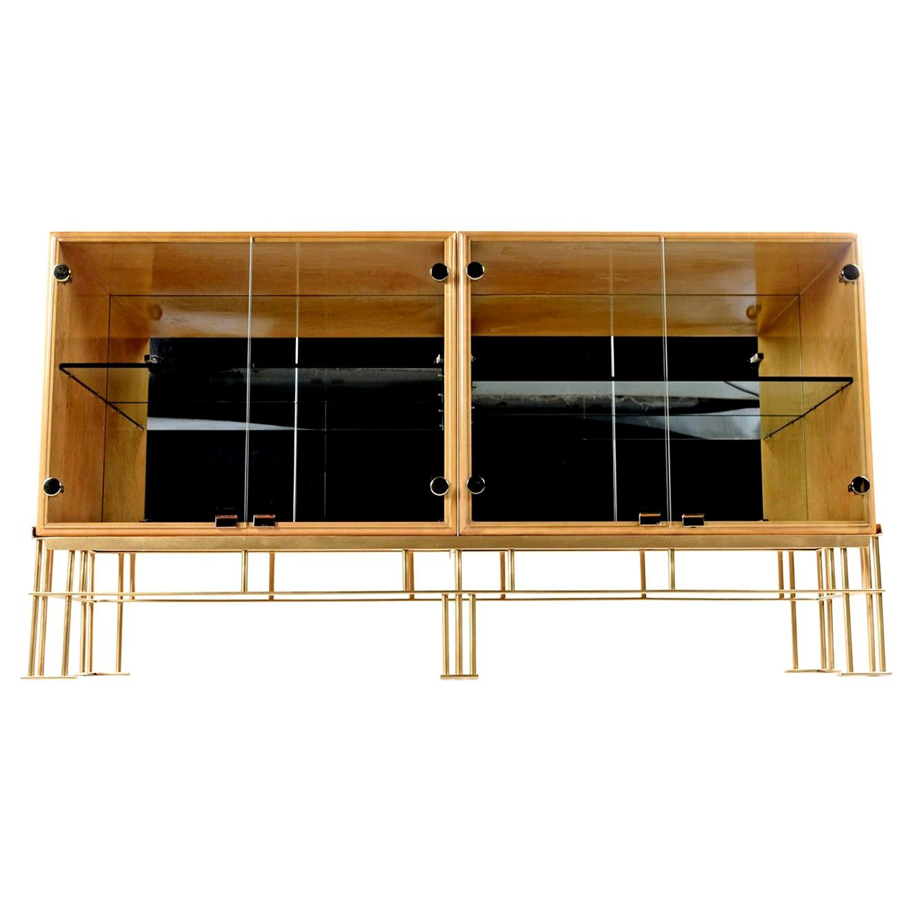 These iridescent lacquered solid bird's-eye maple wood cabinets with their polished brass accents are sure to make this piece the focal point of any room. The two glass door cabinets features a mirrored back and adjustable glass shelf, allowing it