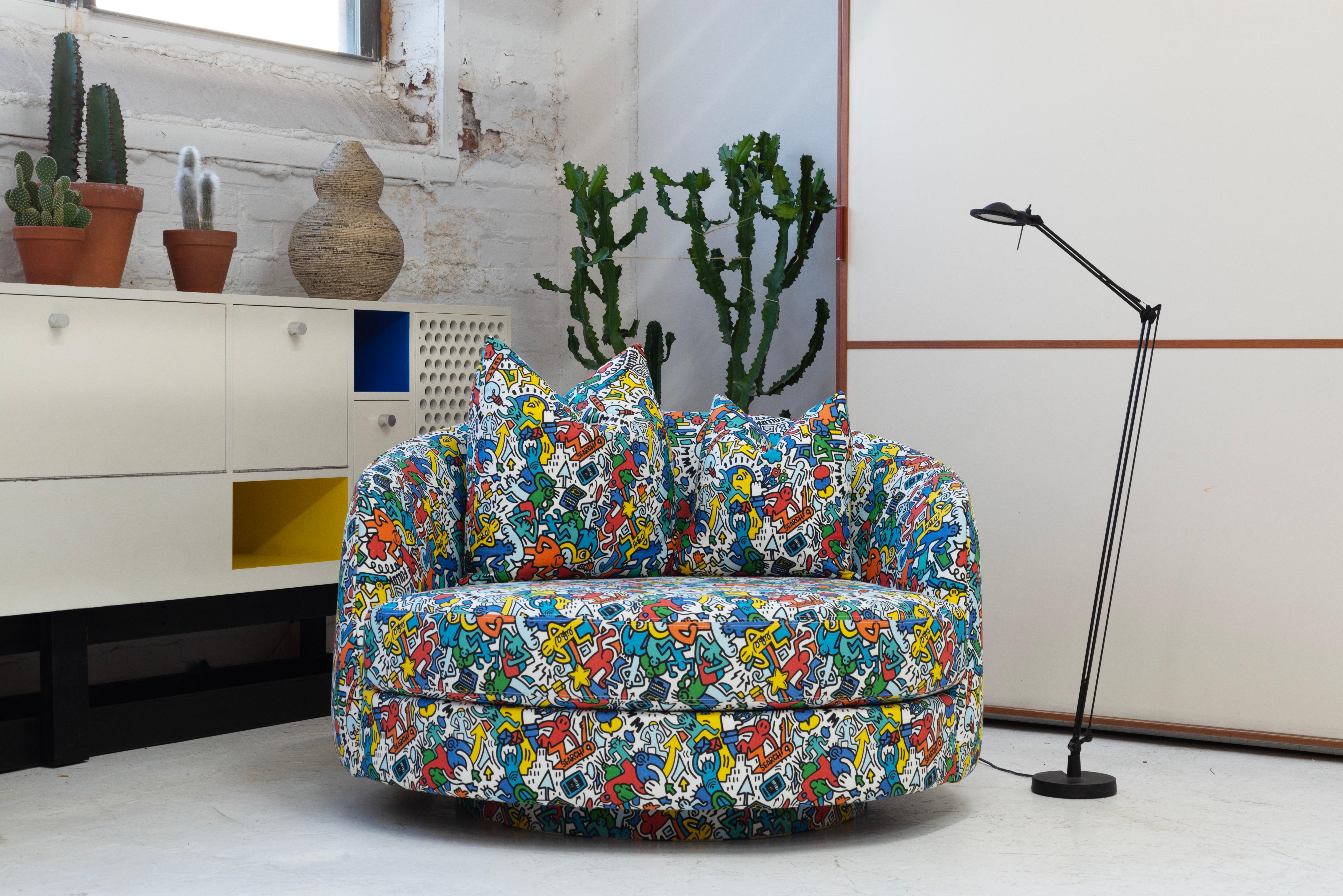 Upholstered with new foam in Keith Haring Style Fabric made in Spain. Chair swivels 360 degrees with two down pillows.