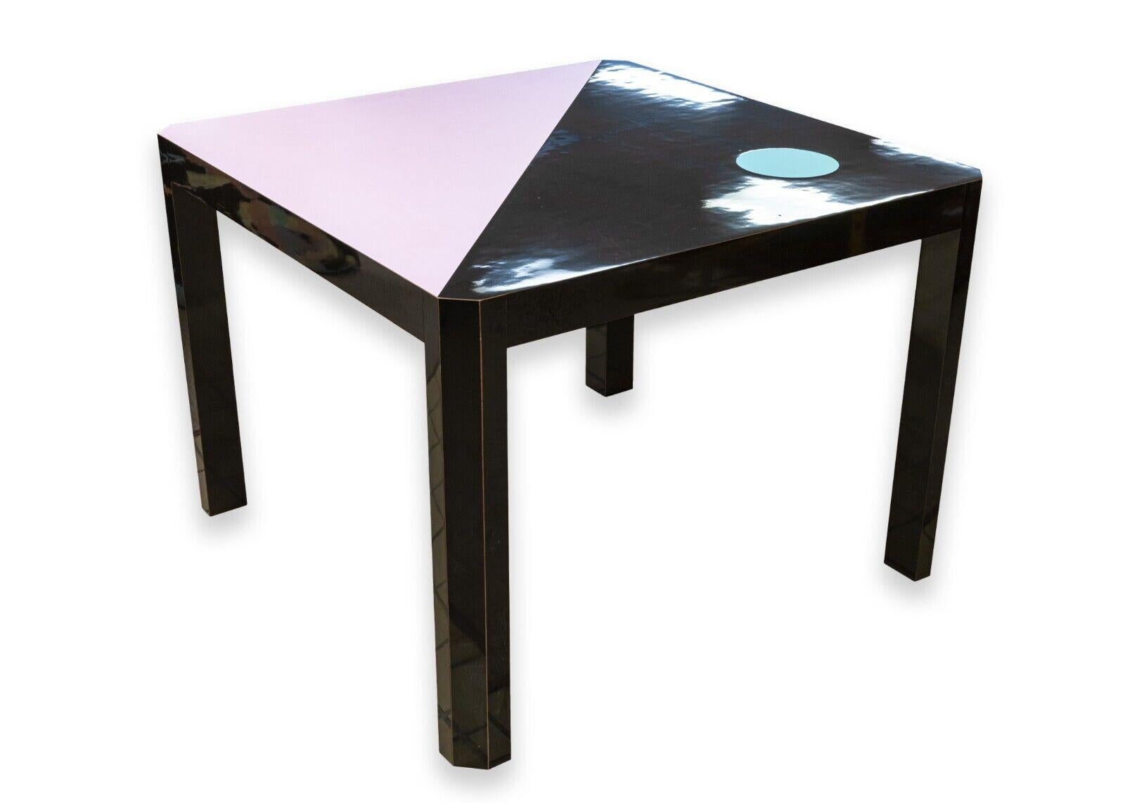 A post modern, super cool, super chic Milo Baughman for Thayer Coggin Memphis style table. The table is a very classic Memphis style table with a square shape, angular legs, a black lacquer finish with a blue circle accent, and a pink side with a
