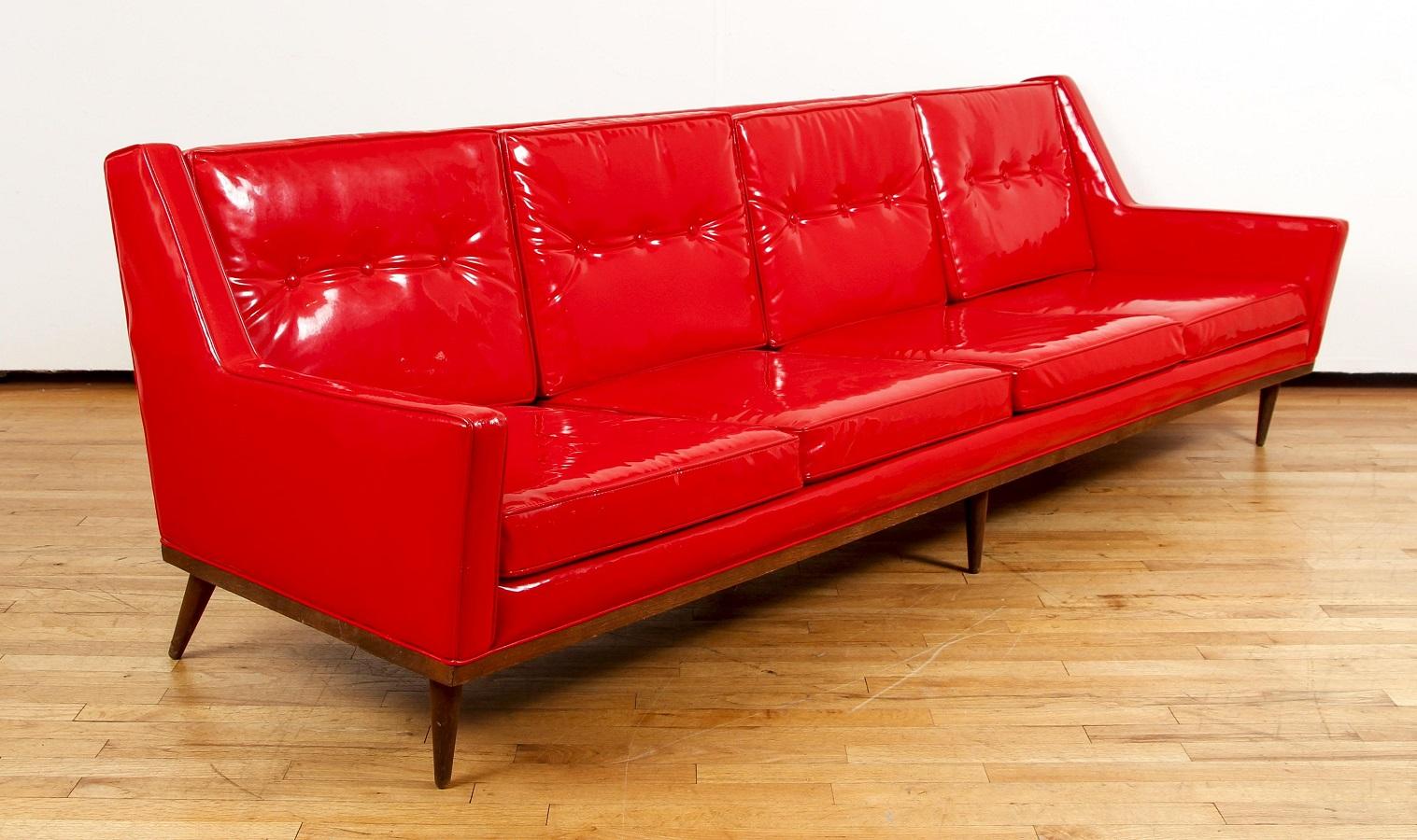 Milo Baughman pour Thayer Canapé en vinyle rouge. Le canapé a un cadre en noyer, de belles lignes modernes du milieu du siècle et des pieds arrière coniques. Le canapé a des coussins de dossier touffus. Les coussins du dossier et de l'assise sont