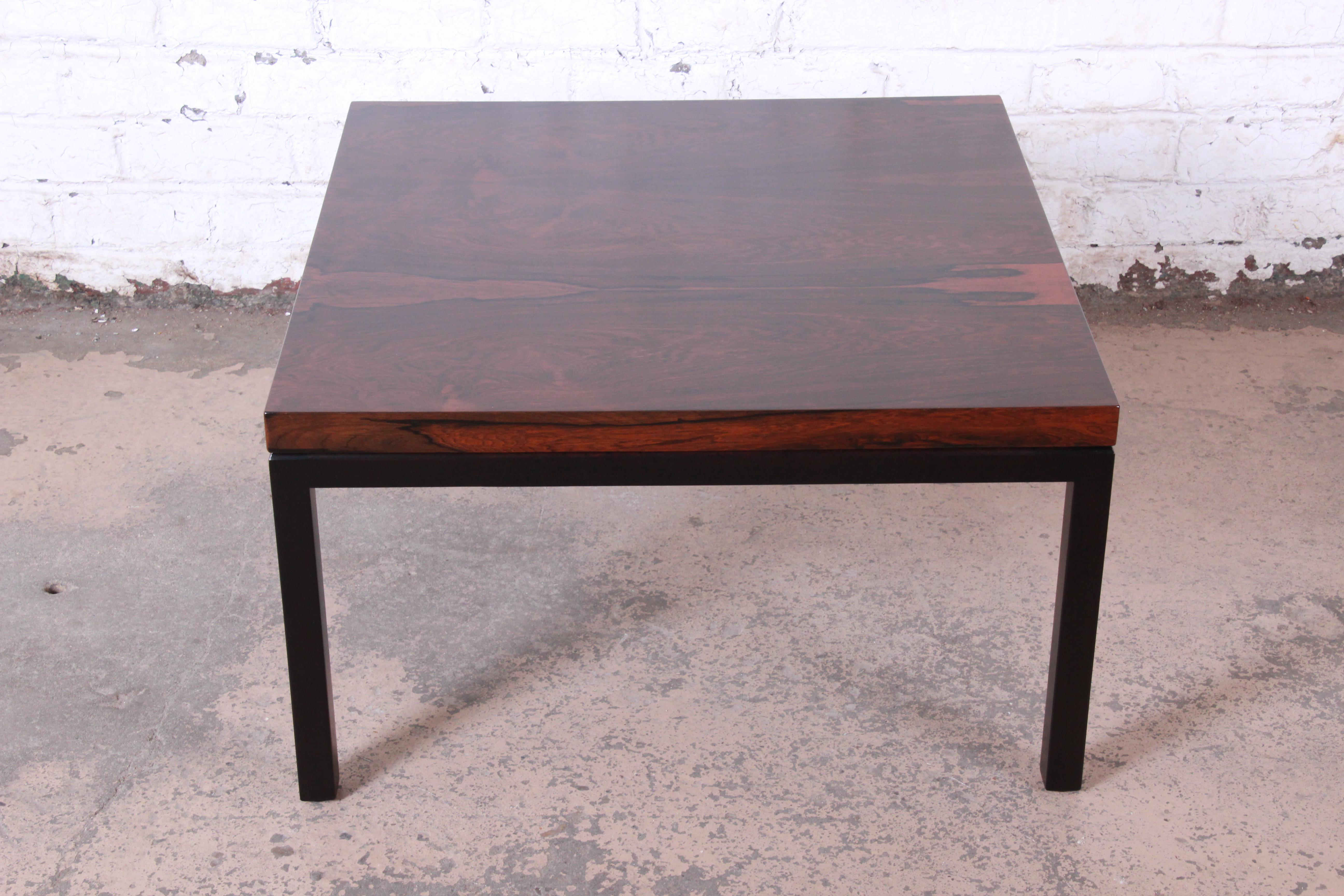 A gorgeous Mid-Century Modern rosewood coffee table designed by Milo Baughman for Thayer Coggin. The table features stunning wood grain on top and sleek ebonized wood legs. An outstanding example of Baughman's iconic design work. The original label
