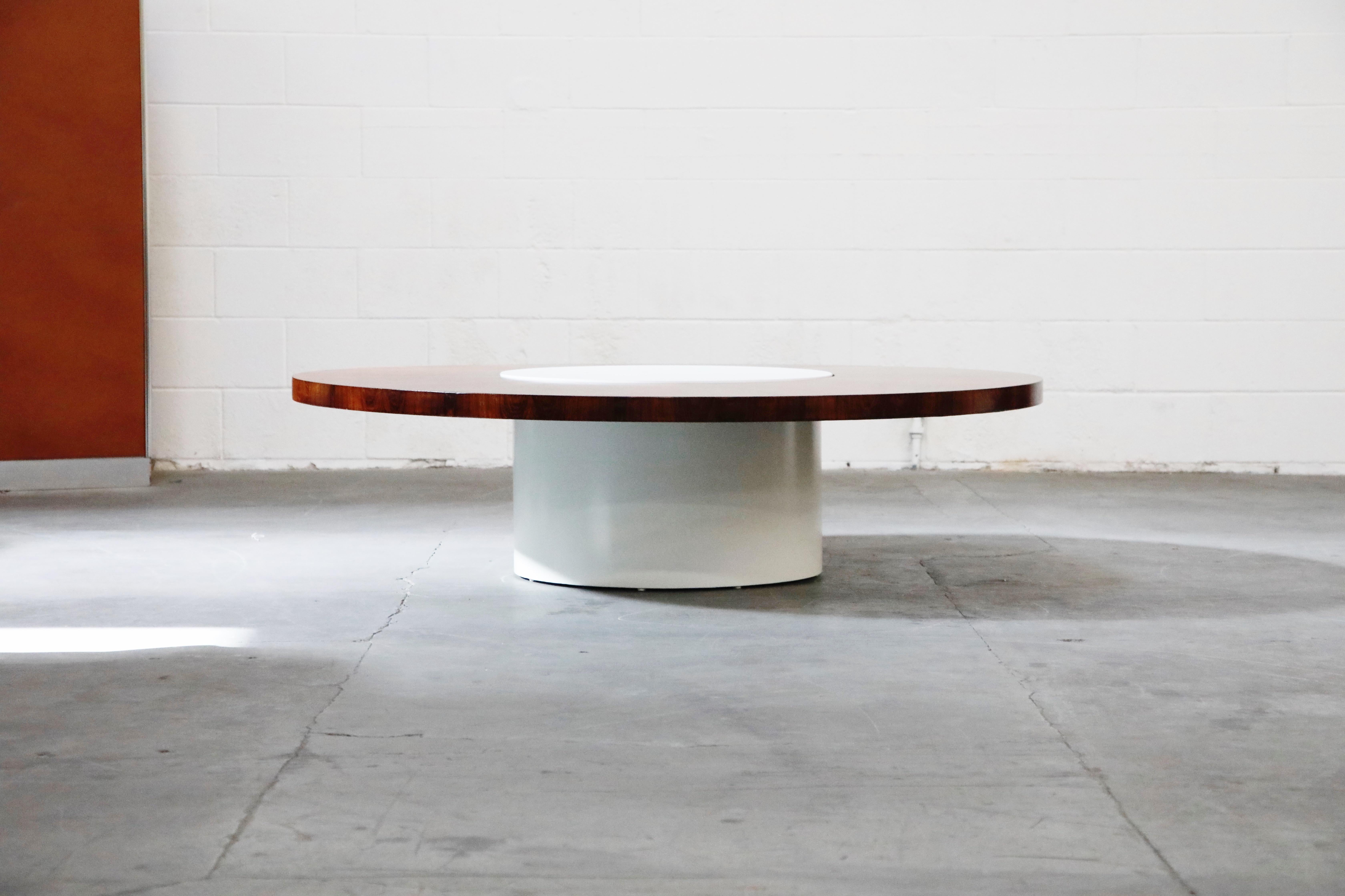 This rare incredible rotating Lazy-Susan cocktail table was designed by Milo Baughman for Thayer Coggin. Featuring a stunning Rosewood top with vivid grain and detail, and a white Formica cylindrical base. The Rosewood top rotates when spun so that