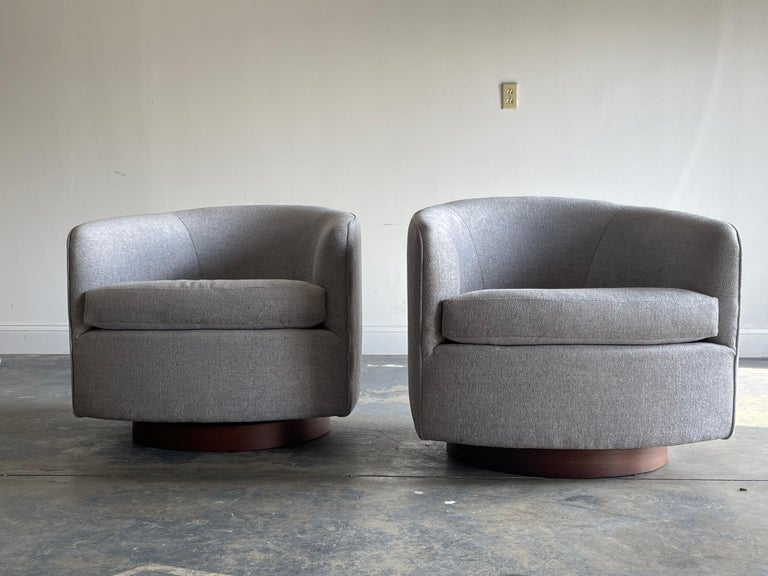 Pair of swivel chairs designed by Milo Baughman for Thayer Coggin. Reupholstered in D1404 Sterling by Charlotte Fabric. Walnut base has new walnut veneer.

Third to last picture shows restoration of base. Last two pictures are from an identical set