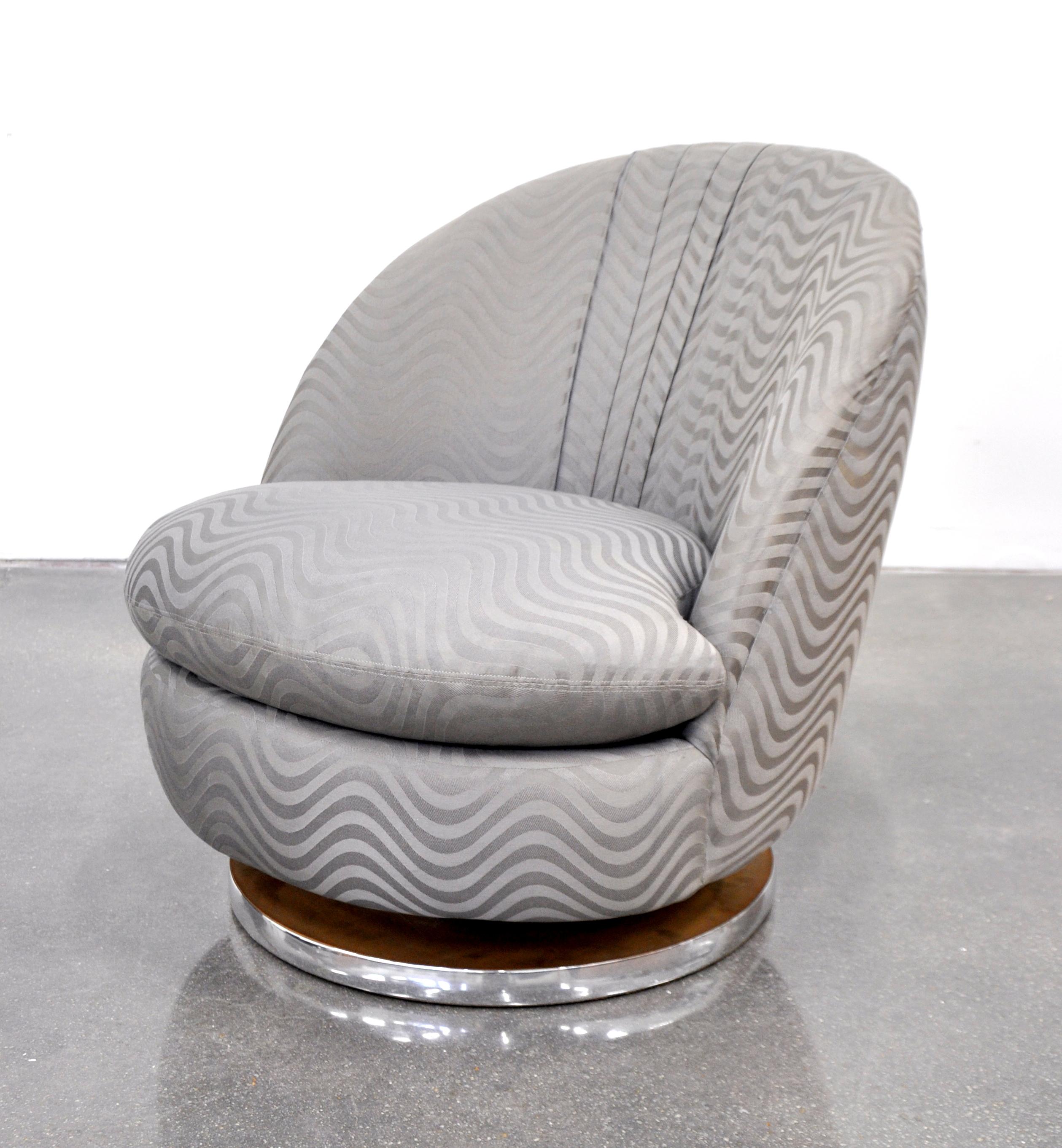 A vintage Mid-Century Modern taupe grey and silver barrel back rocking chair, featuring a chrome accented base with tilting and swiveling mechanism, and original upholstery. An extremely comfortable clam shell shaped slipper chair designed by Milo