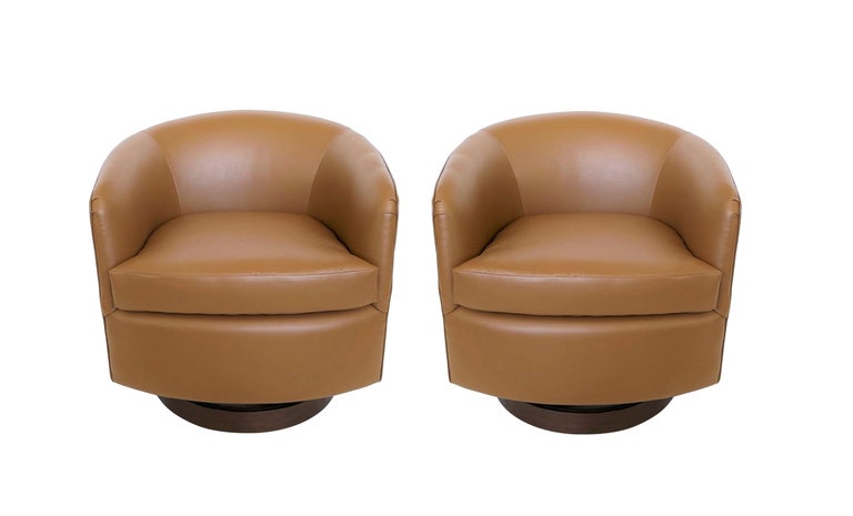 The classic tub chairs with soft, curved design lines designed by Milo Baughman for Thayer Coggin, circa 1960's. The bases not only swivel, but also include a rocking mechanism to achieve optimal comfort at the perfect pitch for each user. The