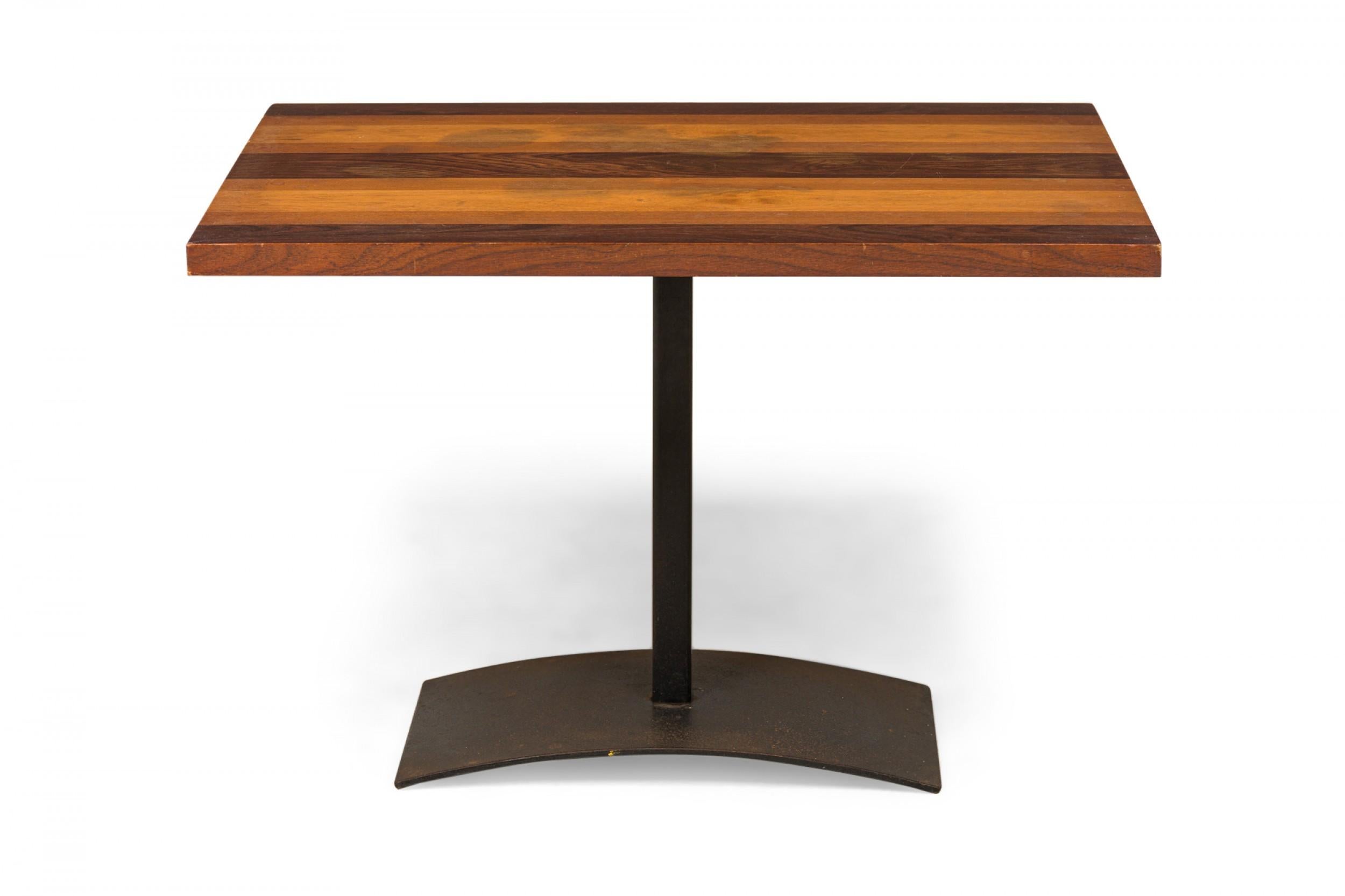 American Mid-Century rectangular end / side table with a tri-tone rectangular wooden top resting on an iron pedestal base with a domed rectangular foot. (MILO BAUGHMAN FOR THAYER COGGIN)
