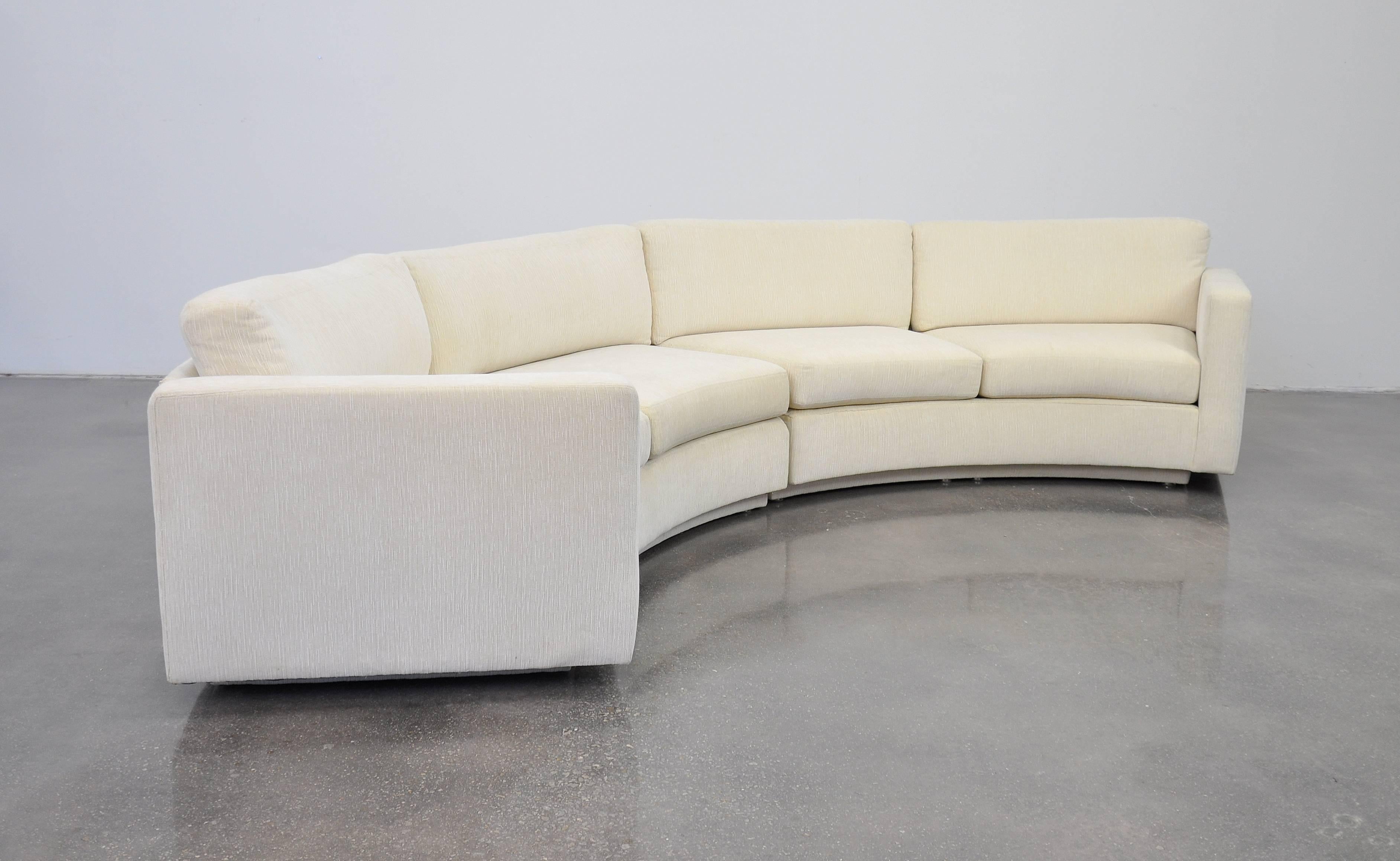 A vintage Mid-Century Modern model 825 semi circular off-white chenille couch or curved sectional, designed by Milo Baughman for Thayer Coggin, dating from the 1980s. The set back plinth base makes the sofa look like its floating. The round