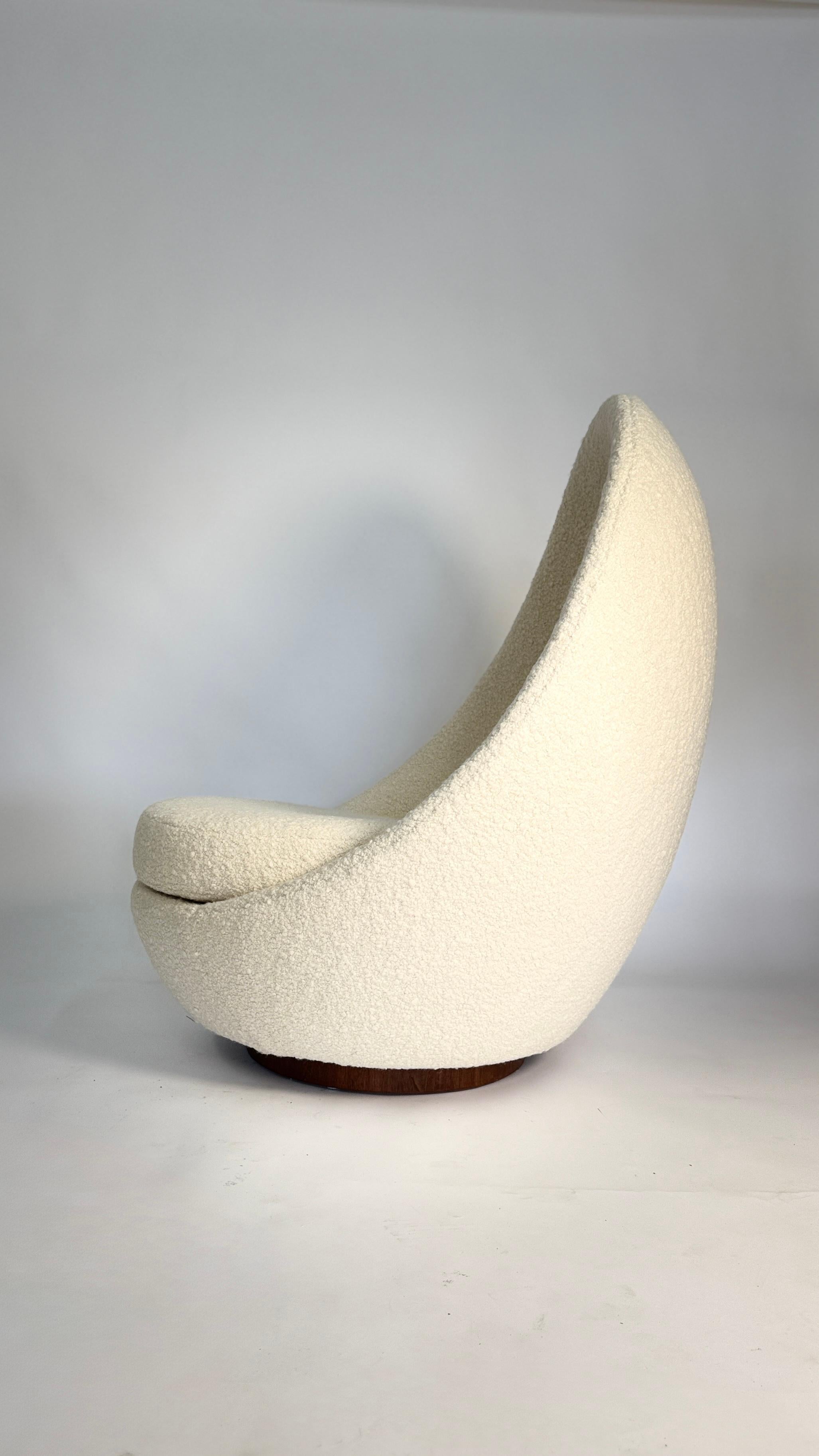 Esta icónica mecedora con respaldo alto, diseñada por Milo Baughman para Thayer Coggin, encarna las atrevidas curvas y la acogedora comodidad del diseño moderno de los años sesenta. La escultural silueta acuna el cuerpo con una forma similar a la de
