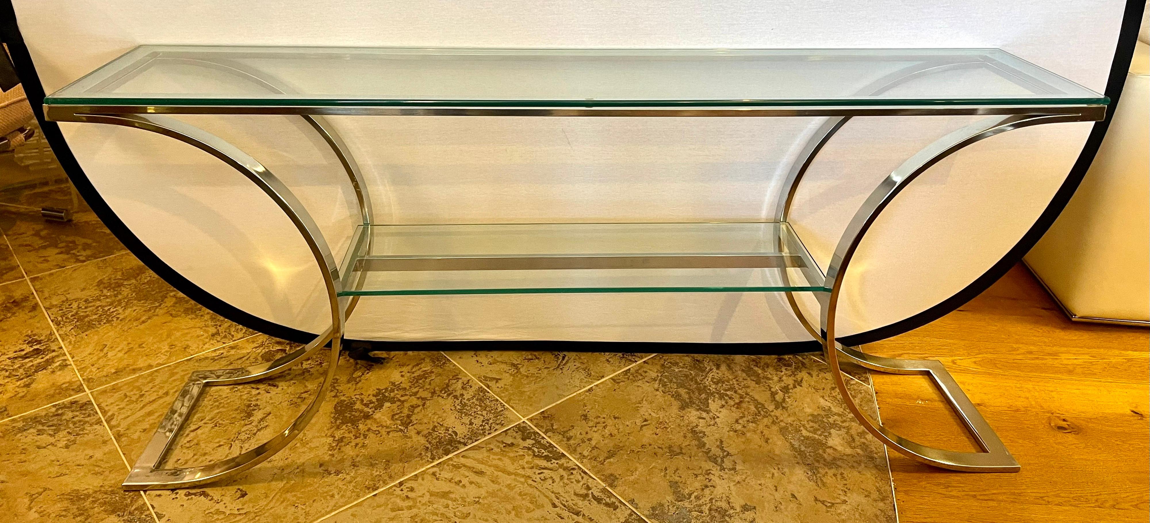 Magnificent Milo Baughman glass top with chrome base console table.
Sculptural base with two levels of glass make this piece look like a sculpture. Nothing short of gorgeous. Glass top is made of thick glass as one would expect. Iconic mid century