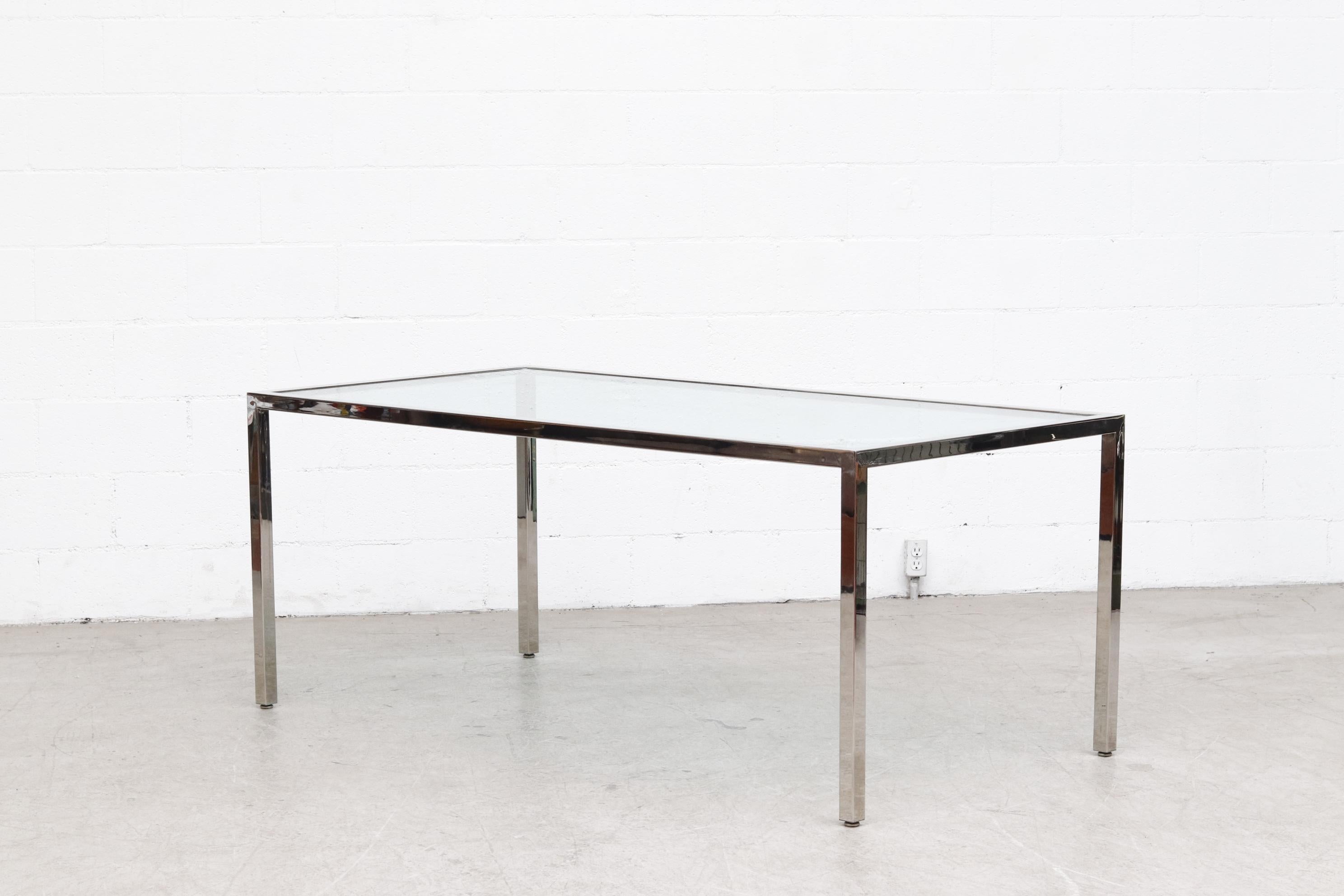 MOD and stylish heavy chrome dining table with inset glass. In good original condition with normal wear. Visible scratches to glass and chrome, consistent with it's age and use.