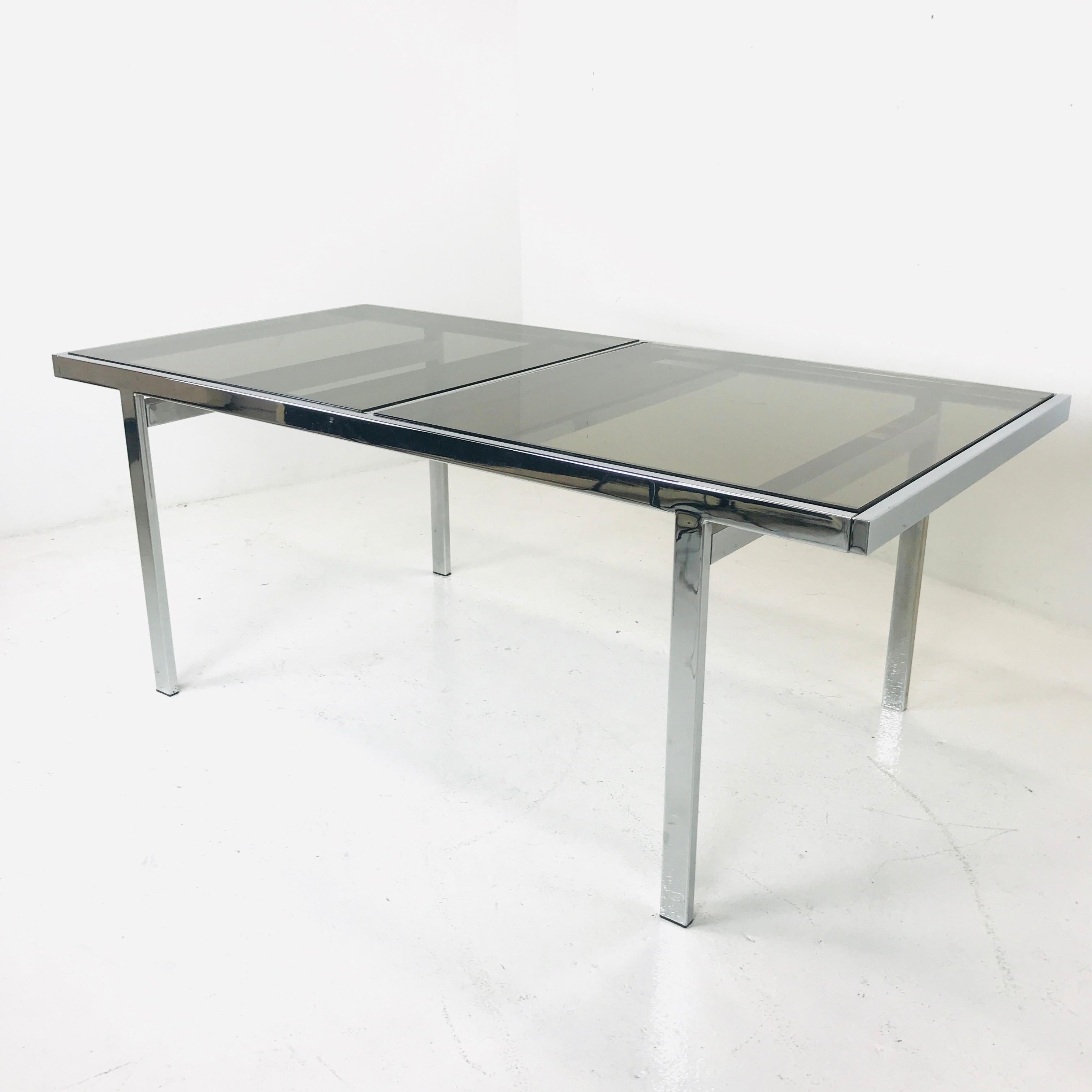 Extendable chrome dining table by Milo Baughman, made of glass and chrome with hidden leaf.
 