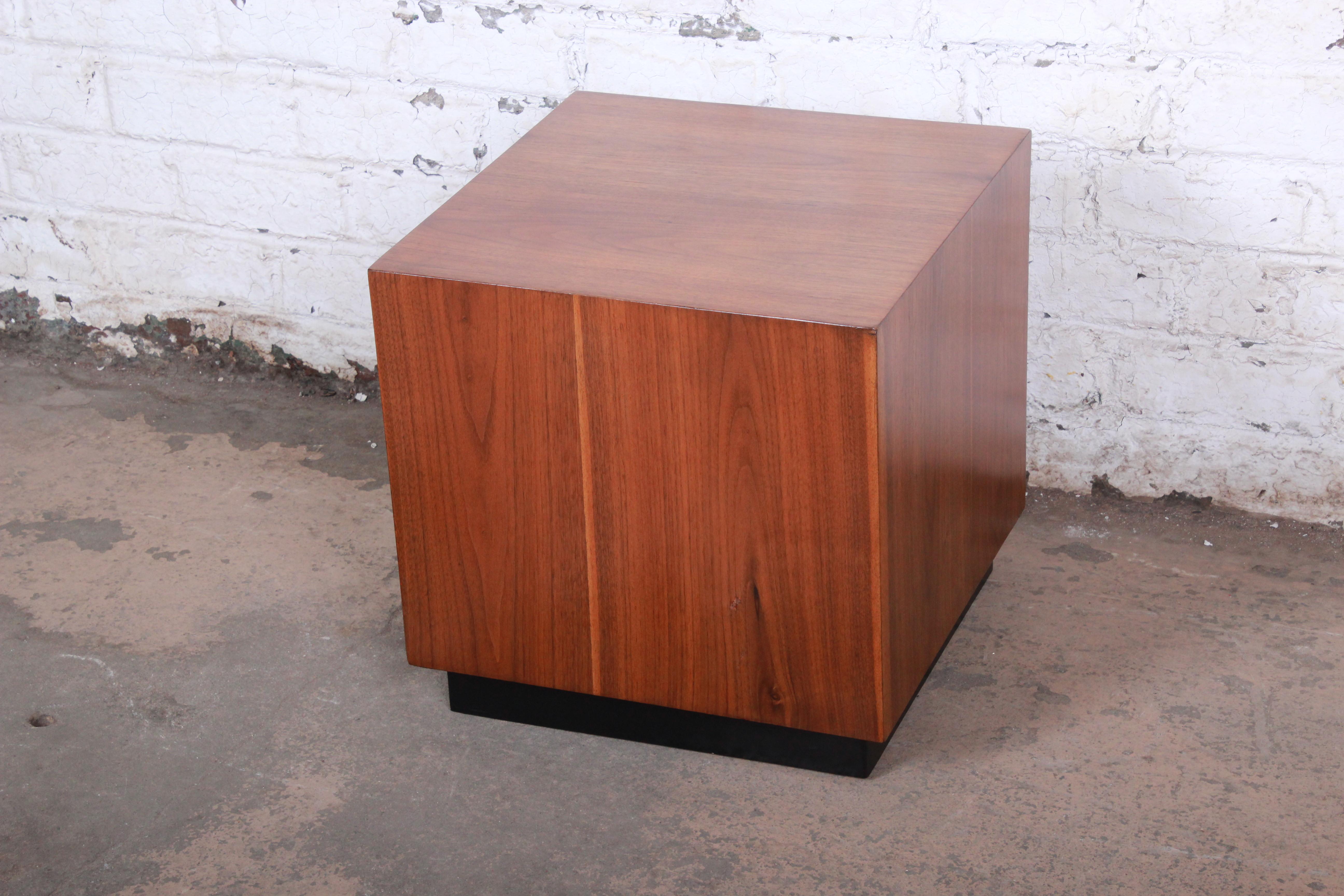 A gorgeous Mid-Century Modern cube side table by Milo Baughman. The table features stunning walnut wood grain and an ebonized plinth base. It is finished on all sides. The table has been refinished and is in very good condition.

Measures 18.88