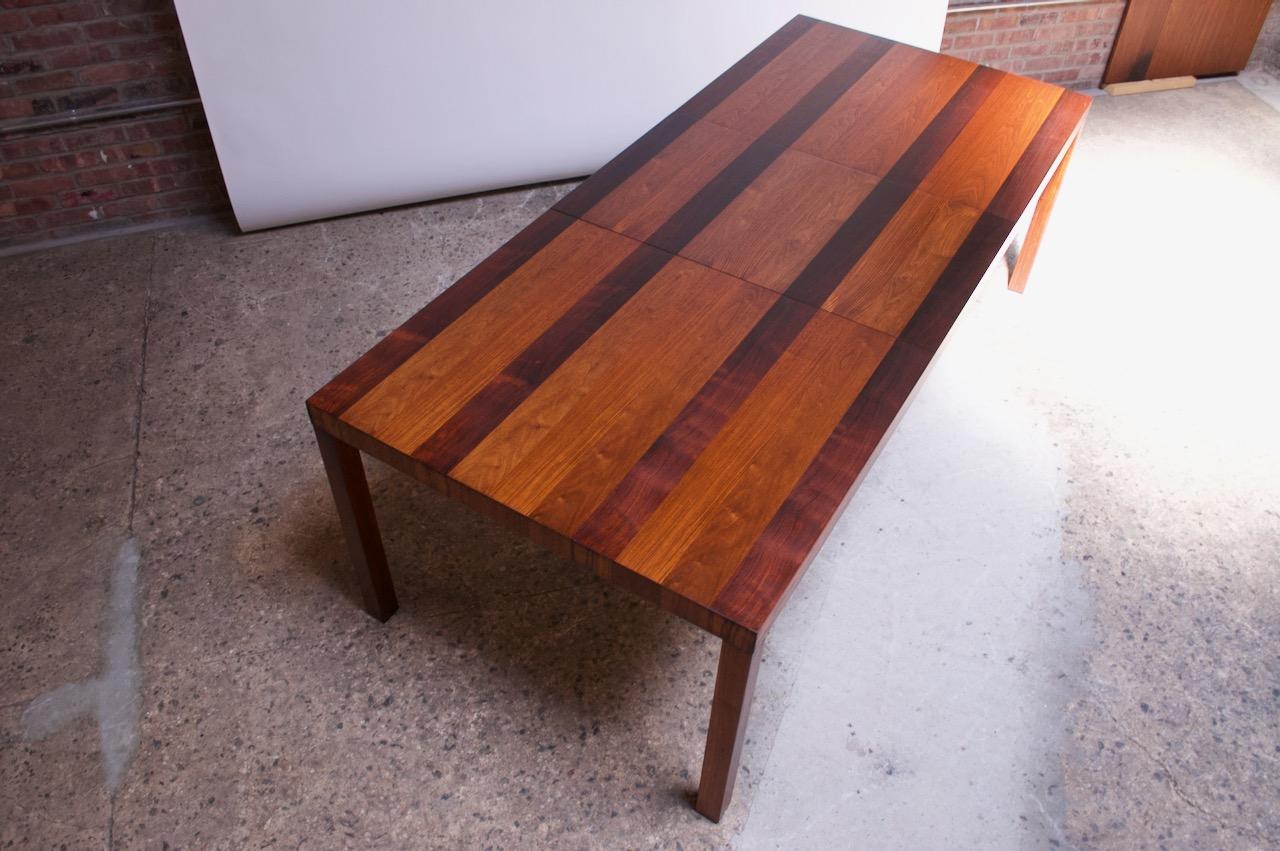 This dining table attributed to Milo Baughman for Directional is composed of teak, walnut, and rosewood banding (scarcely seen wood combination for these tables). Additionally, the legs are rosewood -- another rare attribute.
The table includes a