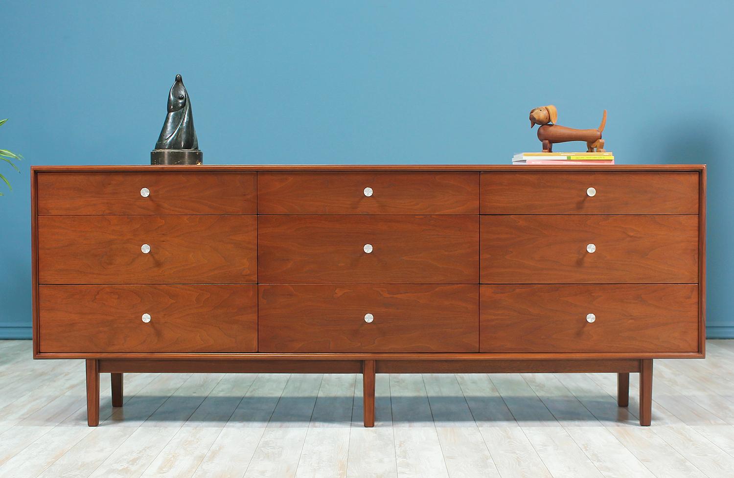 Mid-Century Modern dresser designed by Milo Baughman for Glenn of California and manufactured in the United States circa 1950’s. This newly refinished walnut wood dresser features a solid base with six rectangular legs accented with beveled edges