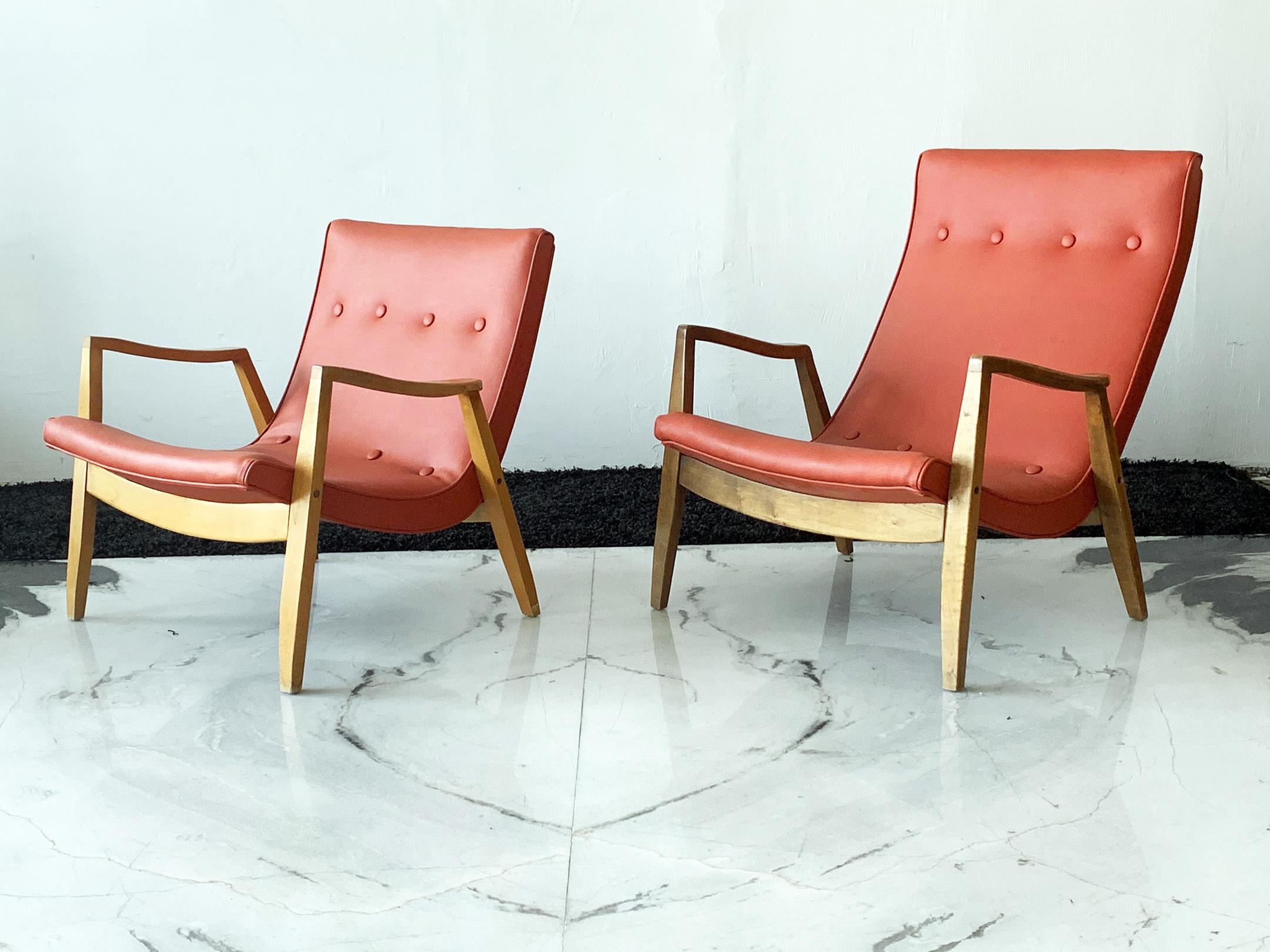 Available right now we have this stunning set of Milo Baughman scoop lounge chairs. The chairs are upholstered in their original coral colored vinyl, and feature solid oak frames and button tufting.

These stunning chairs, designed by Milo