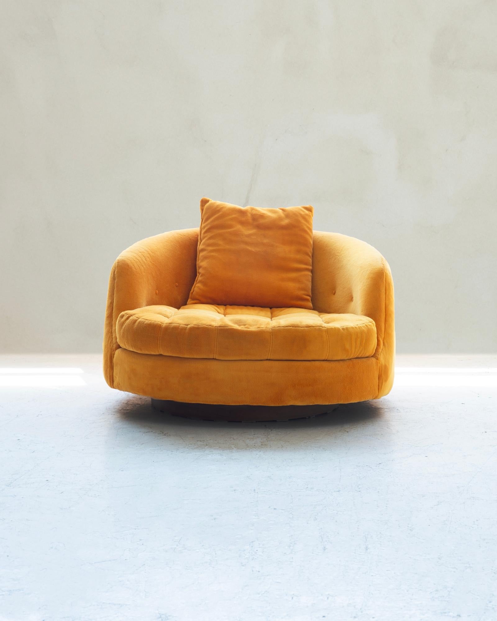 A luxurious oversized swivel tub chair designed by Milo Baughman for Thayer Coggin. This exquisite piece boasts its original upholstery, preserving the authentic charm of its era. The back features elegant button detailing, while the seat is