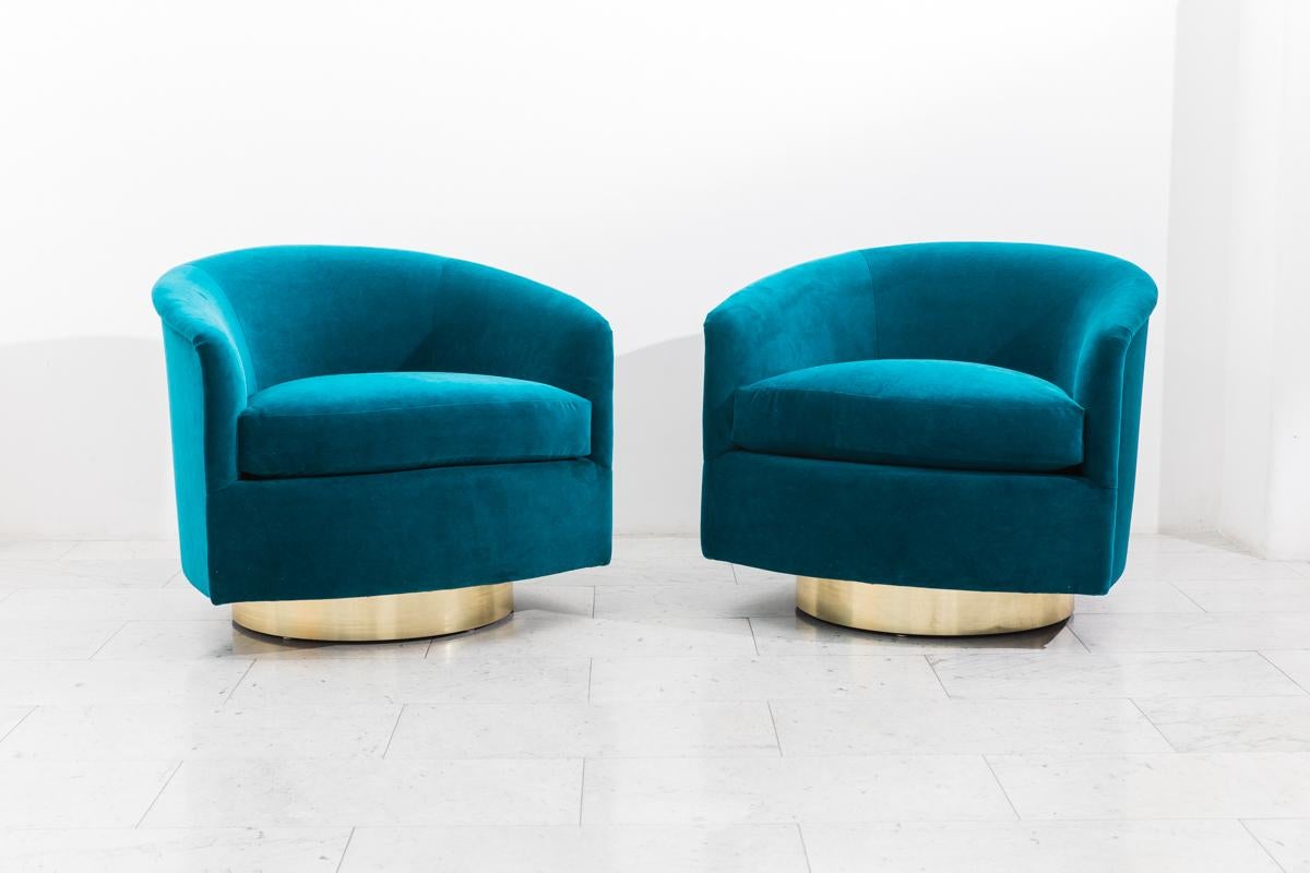 A beautiful pair of swivel chairs designed by Milo Baughman. Each chair has a circular brass base that swivels with ease. Elegant in design, the chairs are also extremely comfortable, offering wonderful back support. The pictured chairs feature new