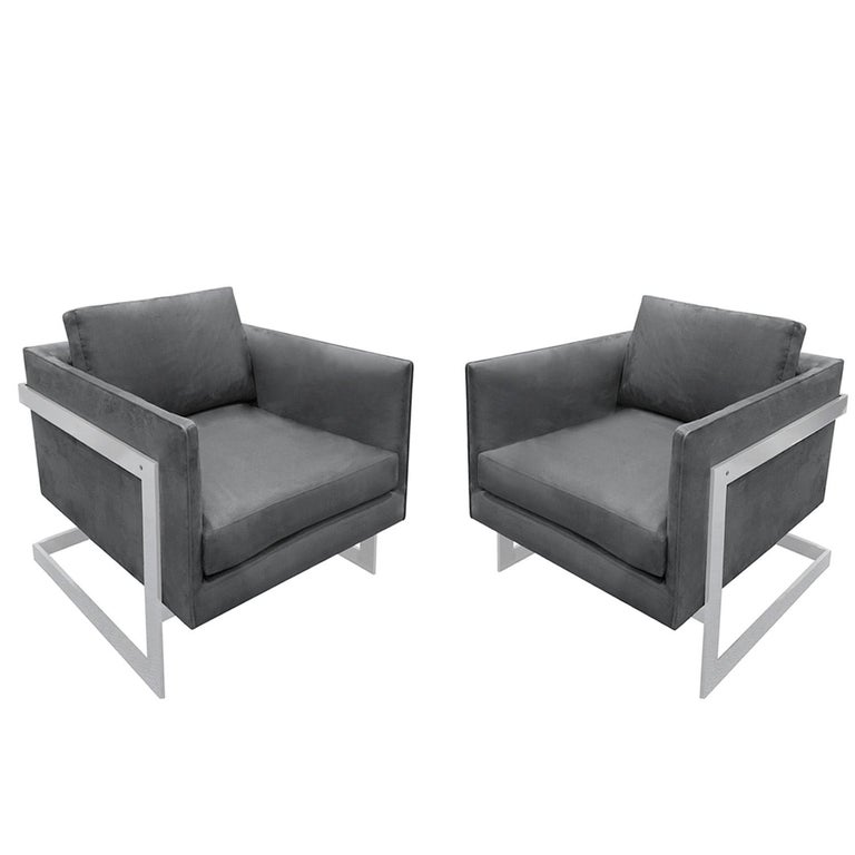 Pair of clean line club chairs with wrap around polished chrome frames by Milo Baughman for Thayer Coggin, American 1970's. Newly reupholstered by Lobel Modern in gray ultrasuede. This is a chic and timeless Baughman design.