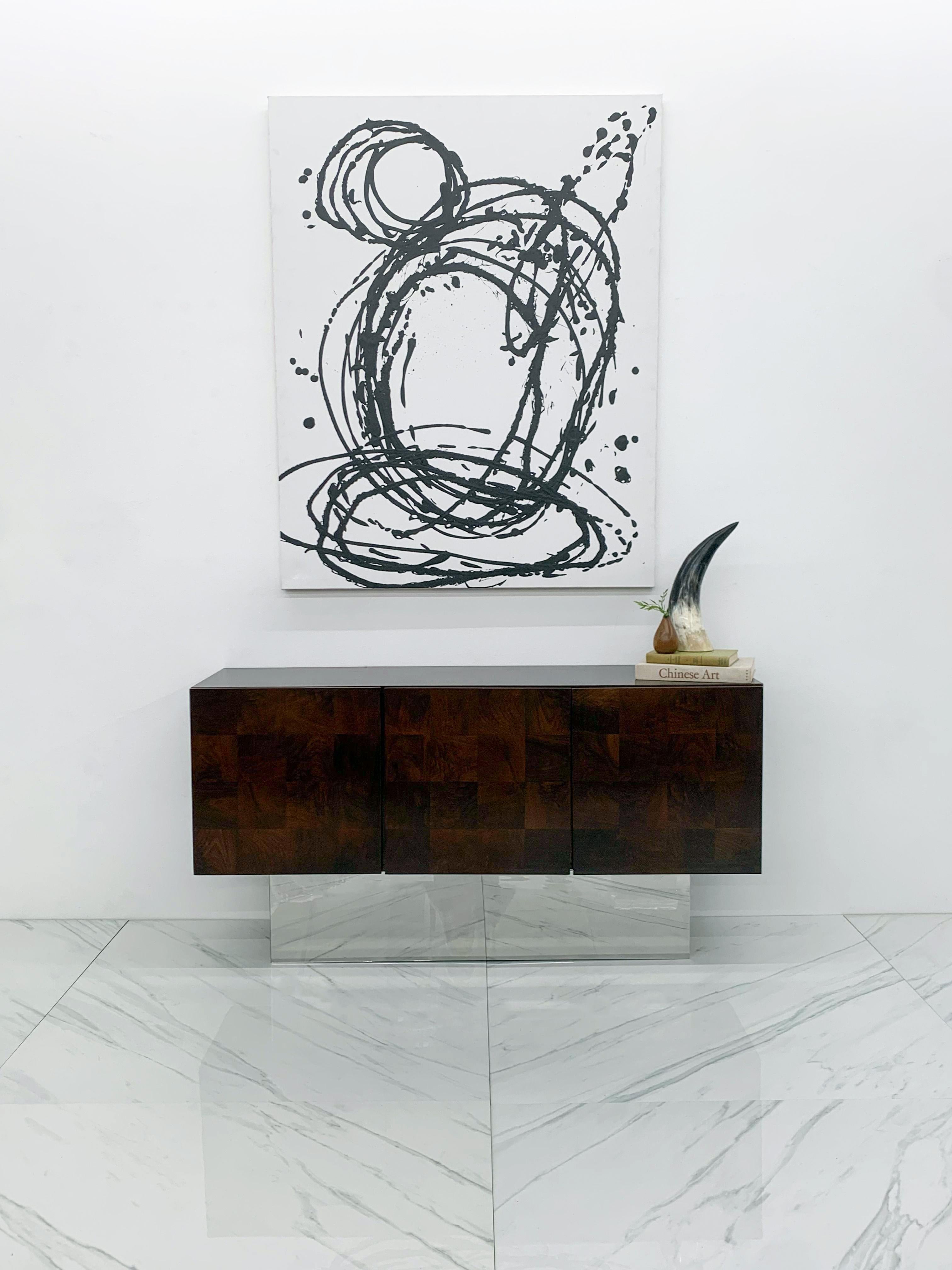 This credenza is absolutely gorgeous! Designed by Milo Baughman for Thayer Coggin in the 1970's this patchwork dark walnut burl and chrome credenza is an absolute show-stopper. This elegant piece of modern furniture features two doors on the right