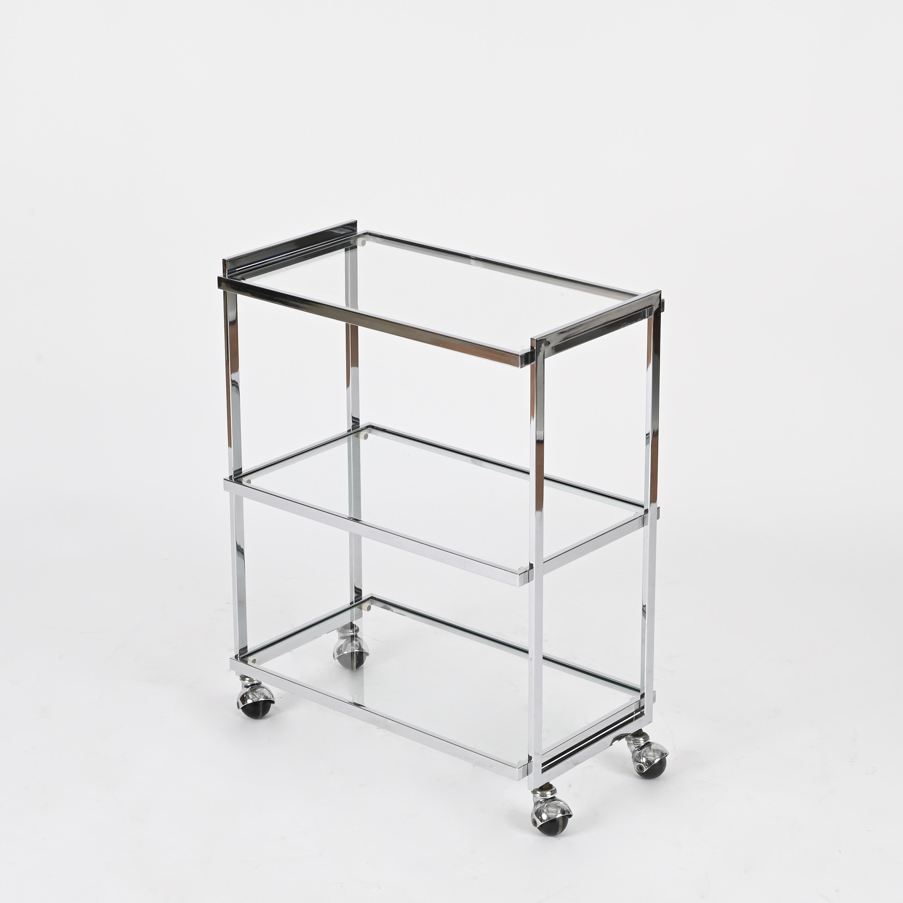 Wonderful and unique Mid-Century three-tier serving bar cart in chrome-plated metal and crystal. This stunning piece is attributed to the mastery of Milo Baughman and was produced in Italy during the 1970s.

Fully original and in amazing condition,