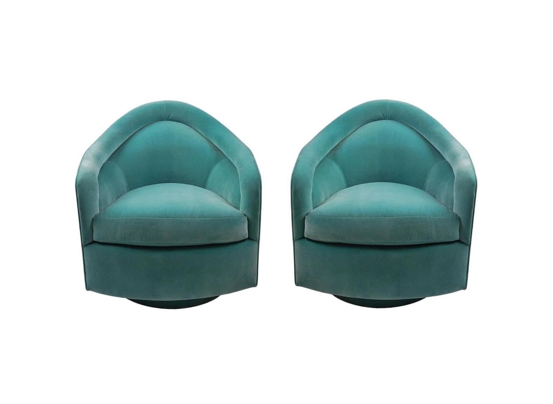 Inviting pair of matching Tear Drop swivel-tilt chairs by American modernist Milo Baughman and manufactured by Thayer Coggin, circa 1970s. Revolutionary construction featuring an enveloping barrel-back set on a plinth base that supports tilt swivel