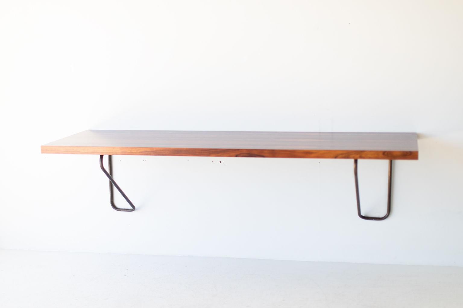 Designer: Milo Baughman

Manufacturer: Thayer Coggin.
Period or model: Mid-Century Modern.
Specs: Rosewood, brass.

Condition:

This Milo Baughman rosewood and brass floating desk for Thayer Coggin is in very good condition. The rosewood top