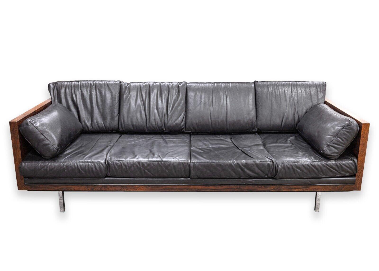 A Milo Baughman rosewood sofa. This is a magnificent mid century modern sofa with a luxurious design and set of materials. This piece features a rare rosewood frame, a soft black leather set of cushions, and shiny chrome legs. This piece is truly a