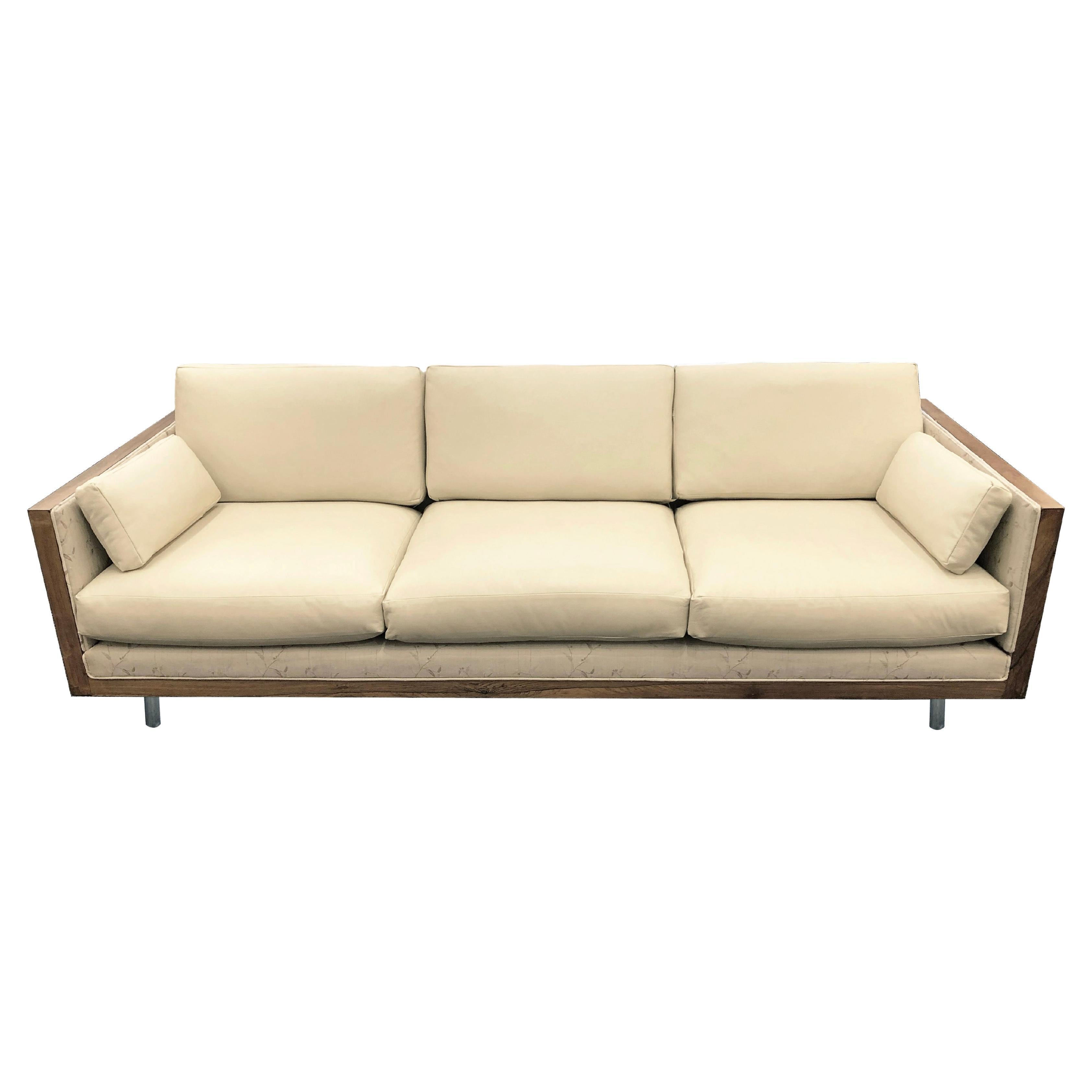 A sofa in the manner of Milo Baughman for Thayer Coggin in warm beige leather wrapped in beautifully figured rosewood, manufactured by Charlton for its 