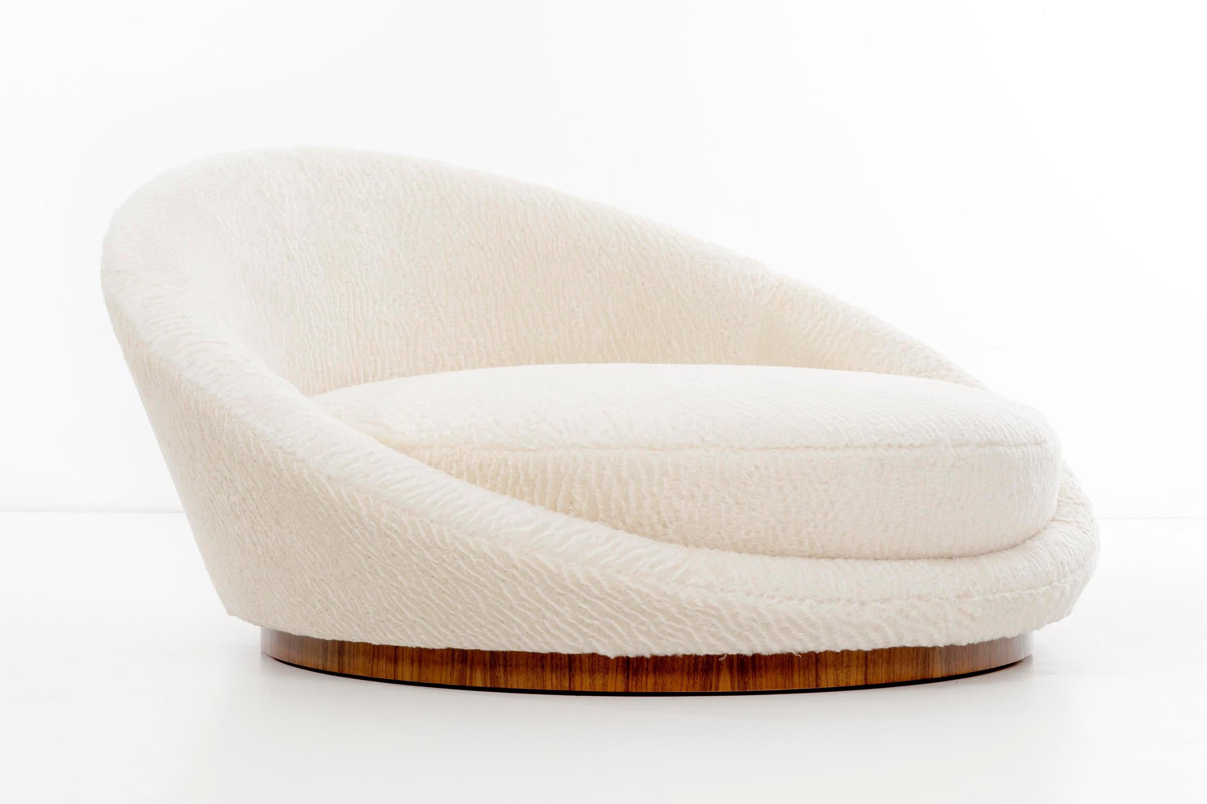 Oversized chaise lounge chair for 1-2 users. Upholstered in faux fur with new foam and walnut plinth base.