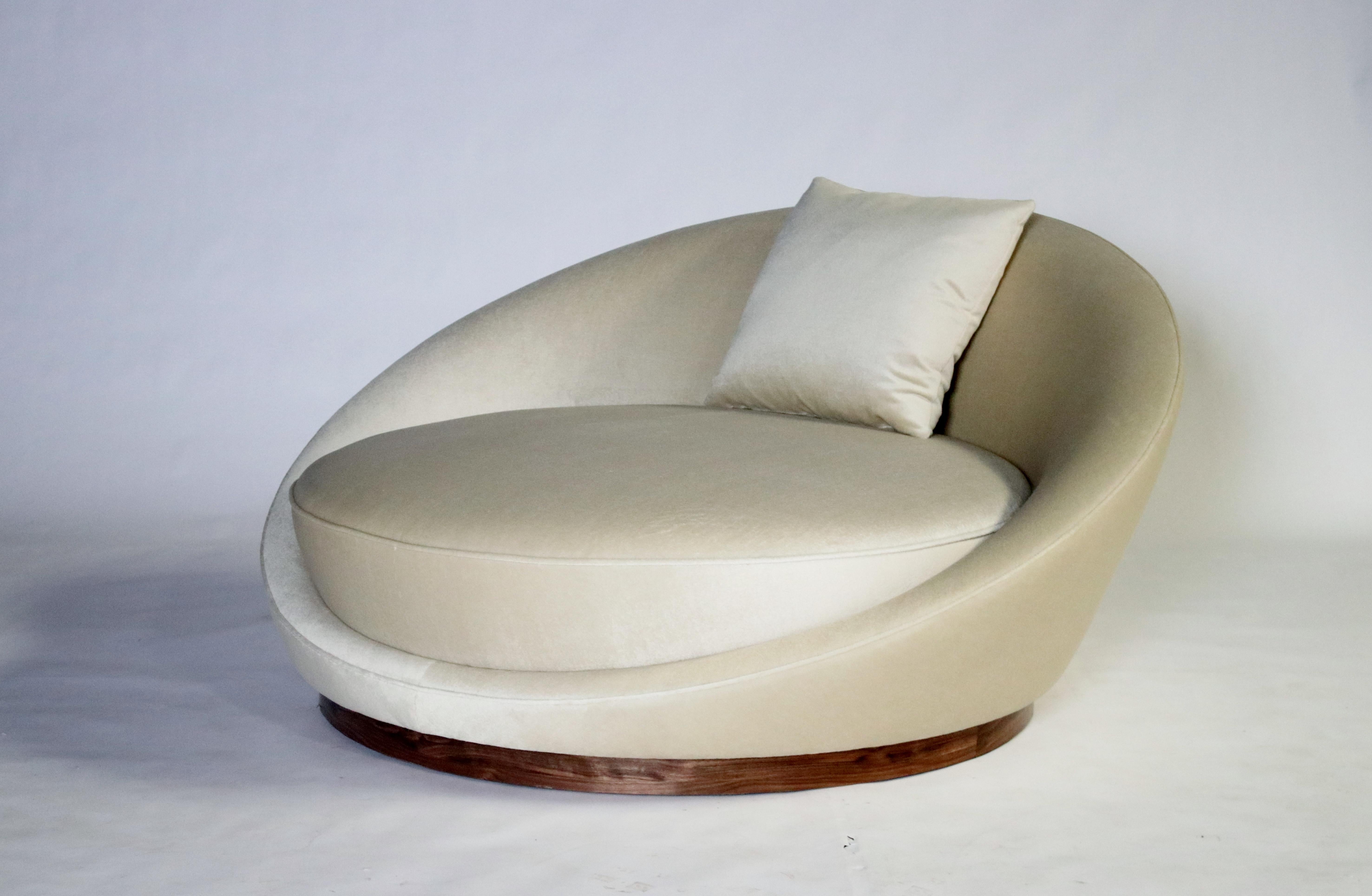 Milo Baughman 1970's round chair or saucer shape chaise lounge on a walnut plinth meticulously restored and reupholstered in a cream color mohair.