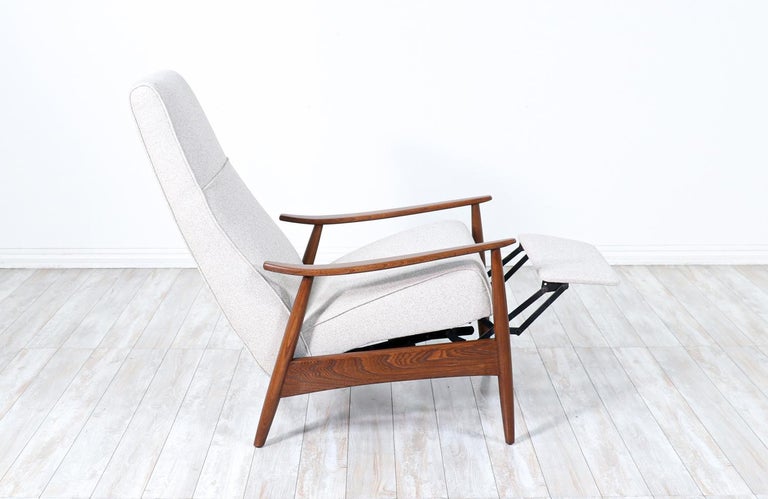 Elegant reclining chair designed by Milo Baughman for James Inc. in the United States circa 1950s. This comfortable Mid-Century Modern recliner features a newly upholstered seat rest in a soft wool blend tweed fabric supported by a warm walnut wood