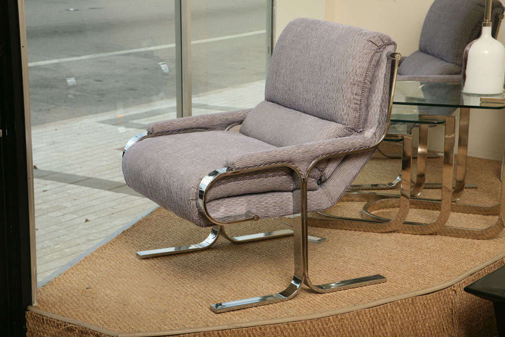 These fantastic pair of stainless steel and upholstered vintage lounge chairs attributed to Milo Baughman feature a polished cantilevered base. They are from the 1970s. They have been newly reupholstered in a stunning silk and chenille stripped blue