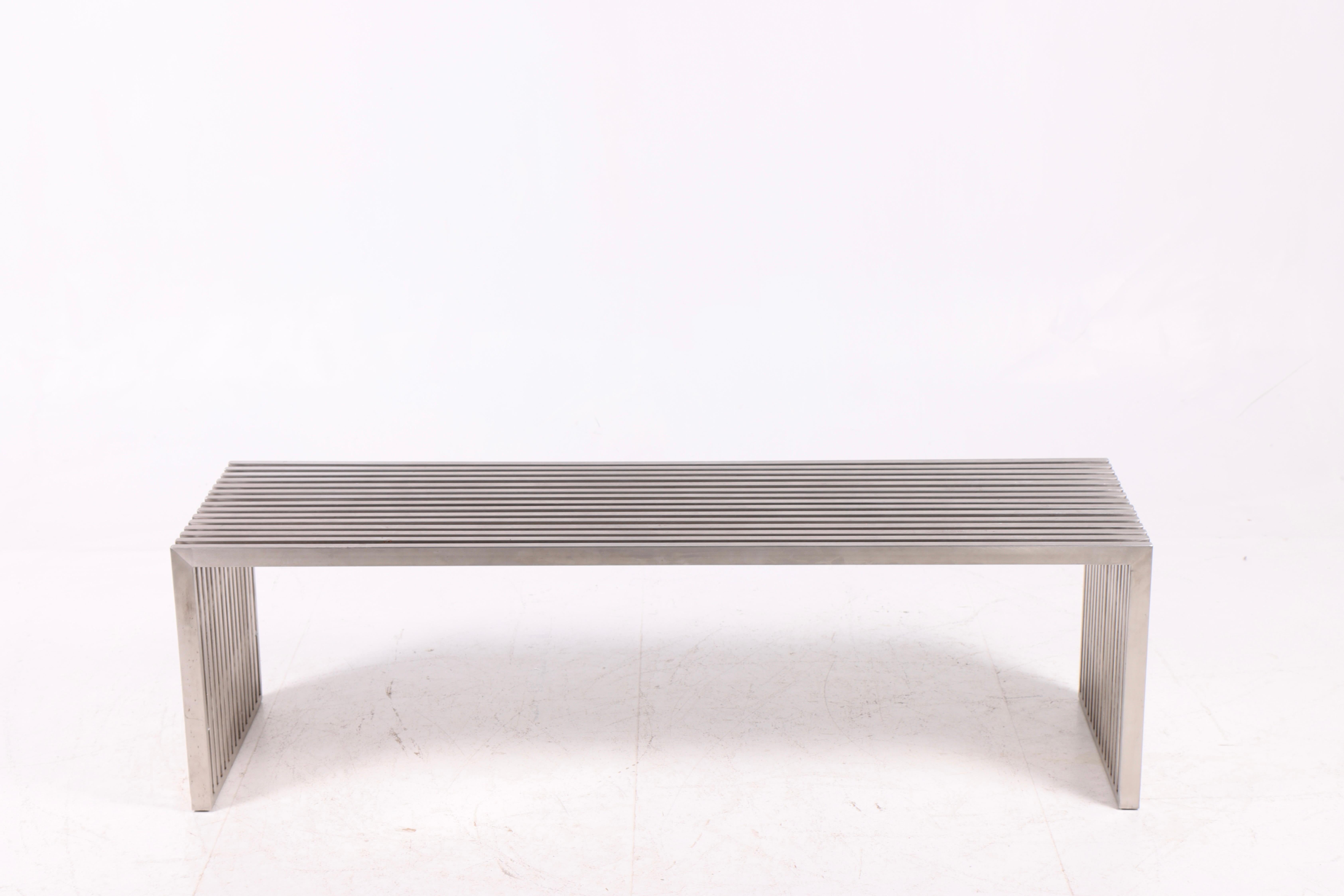 Elegante y minimalista banco o mesa de centro diseñado por Milo Baughman en la década de 1970. Fabricada en acero macizo con un característico diseño de listones, la pieza combina una expresión ligera y escultural con una construcción robusta y
