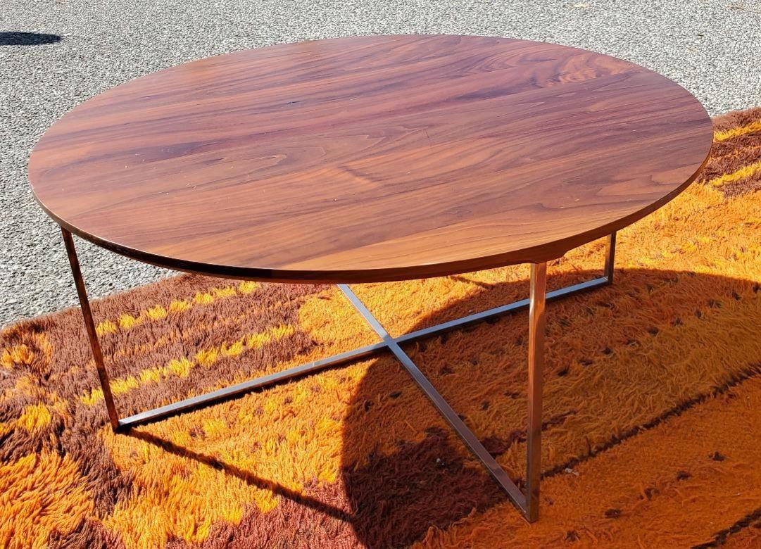 1970 Round Walnut Solid Coffee / Cocktail Table With Chrome X Base In The Style Of Milo Baughman. Ce plateau de table en noyer massif au grain de noyer complètera votre maison ou votre bureau. La base chromée en X est en excellent état. Le plateau