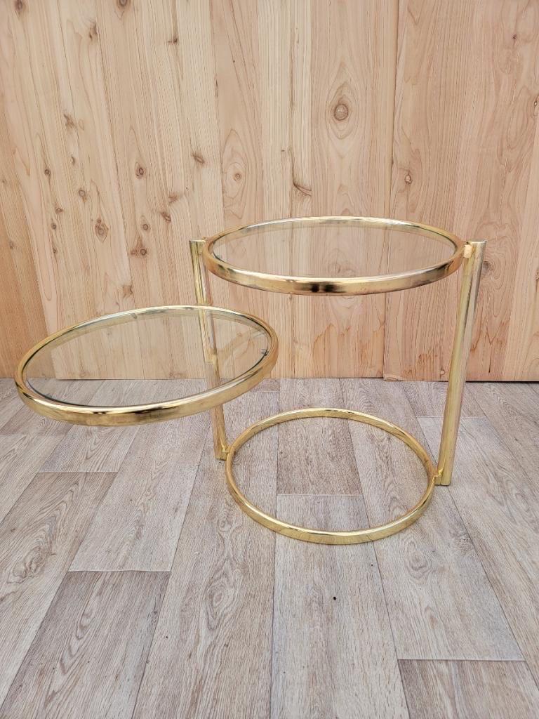 Mid-Century Modern Milo Baughman style articulating 2 tier brass and glass cocktail table.

Mid-Century Modern Milo Baughman style two-tier articulating swivel brass accent or side table. Tubular brass plated frame features two removable round