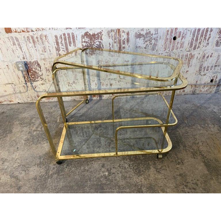 Iconic expandable rolling bar cart by design institute of America. Multiple glass shelves and unique unfolding design. Very good vintage condition with only very minor signs of use appropriate with age. Expands to 87