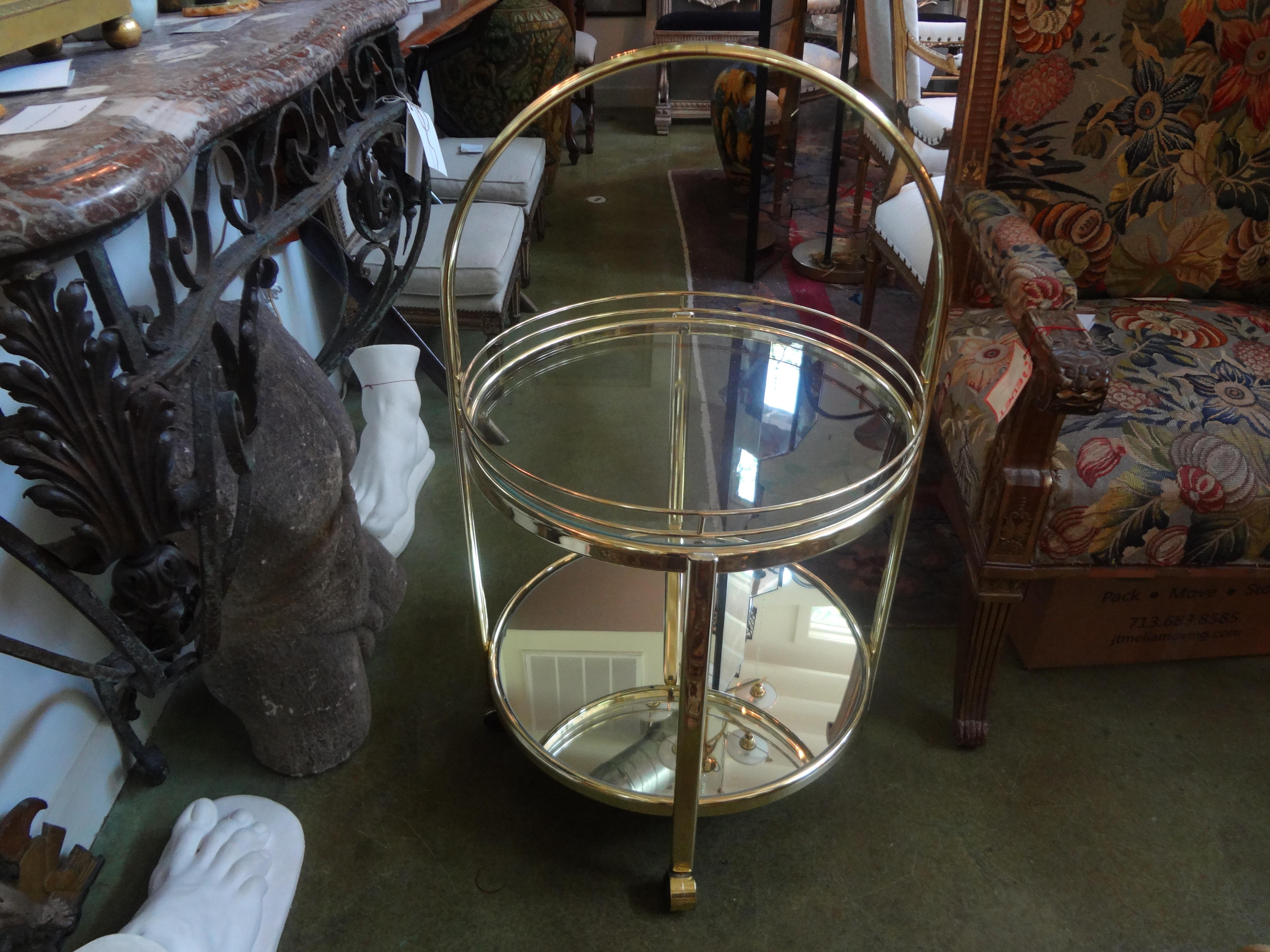 Milo Baughman style brass bar cart.
Interesting Milo Baughman inspired brass bar cart, drinks cart or drinks trolley. This great mid-century circular brass bar cart is two-tiered. The top is glass and the bottom is mirrored. This possibly Italian