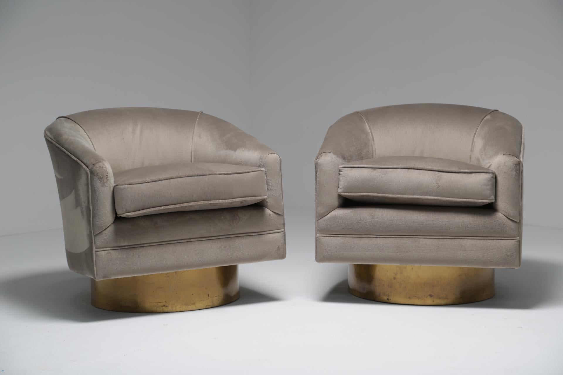 A pair of Milo Baughman style Mid-Century Modern swivel chairs reupholstered in a high -quality luxe silver-grey velvet fabric. These stunning barrel shaped tub chairs sit on simulated brass laminated bases and are very comfortable indeed. The