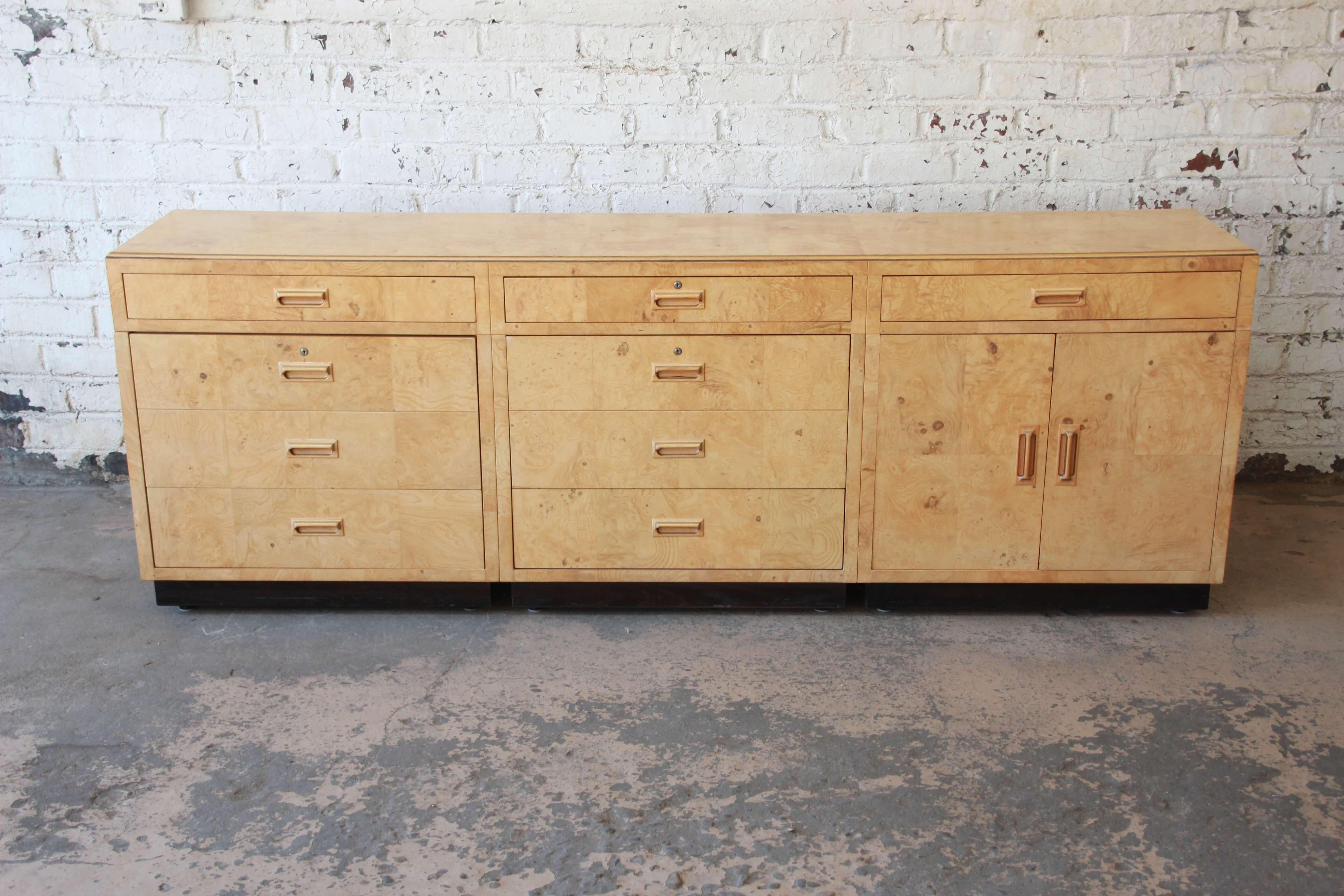 Offering a stylish long burl wood credenza or bar cabinet in the style of Milo Baughman by Henredon Furniture. The piece features three locking drawers, two very large double drawers for storing files or liquor. There are a total of seven drawers