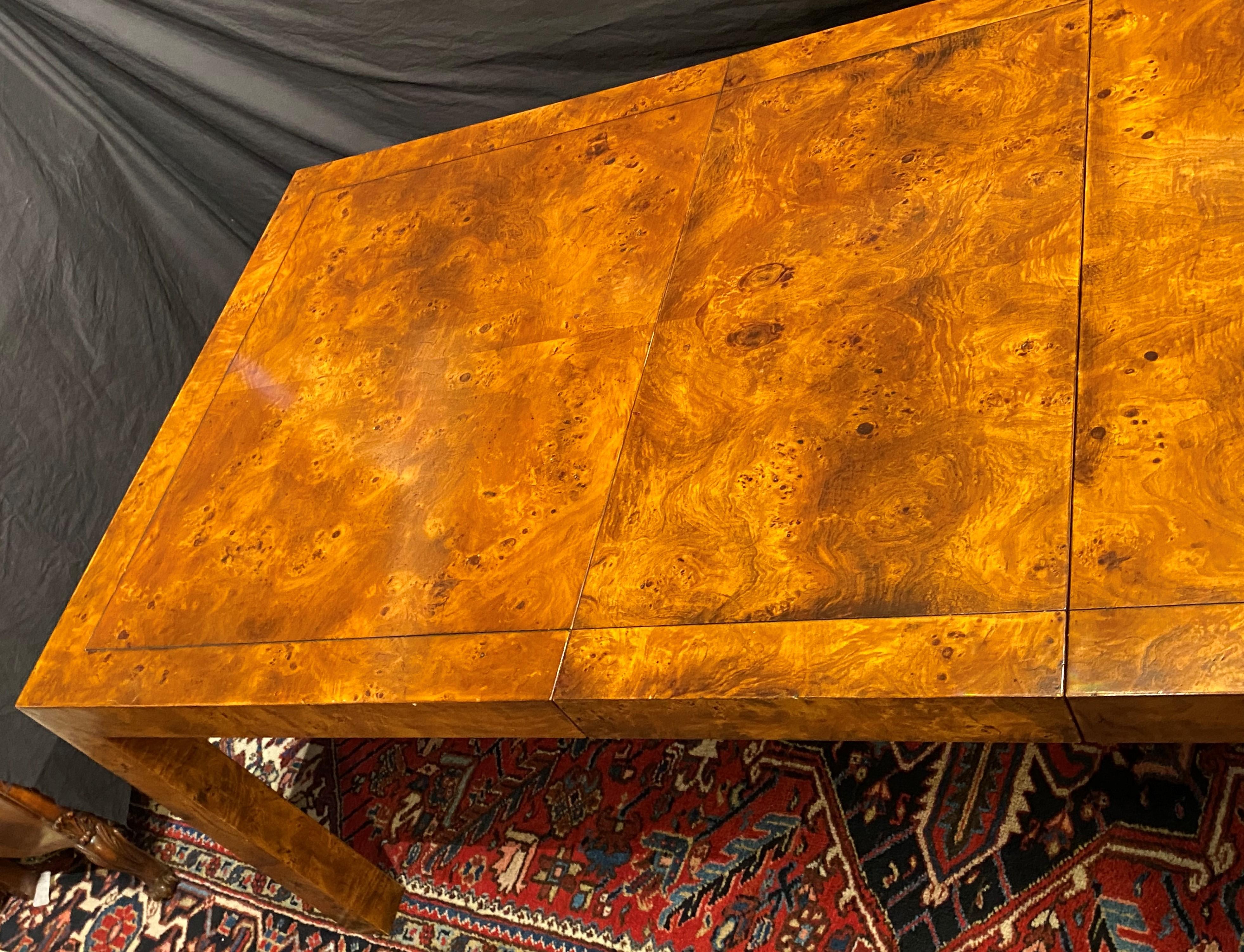 A beautiful Milo Baughman style parsons dining table with two 18 inch leaves, featuring burlwood veneers. Waterfall slide mechanism for leaves. In very good overall condition, with minor surface scratches, touch-ups, and wear commensurate with age