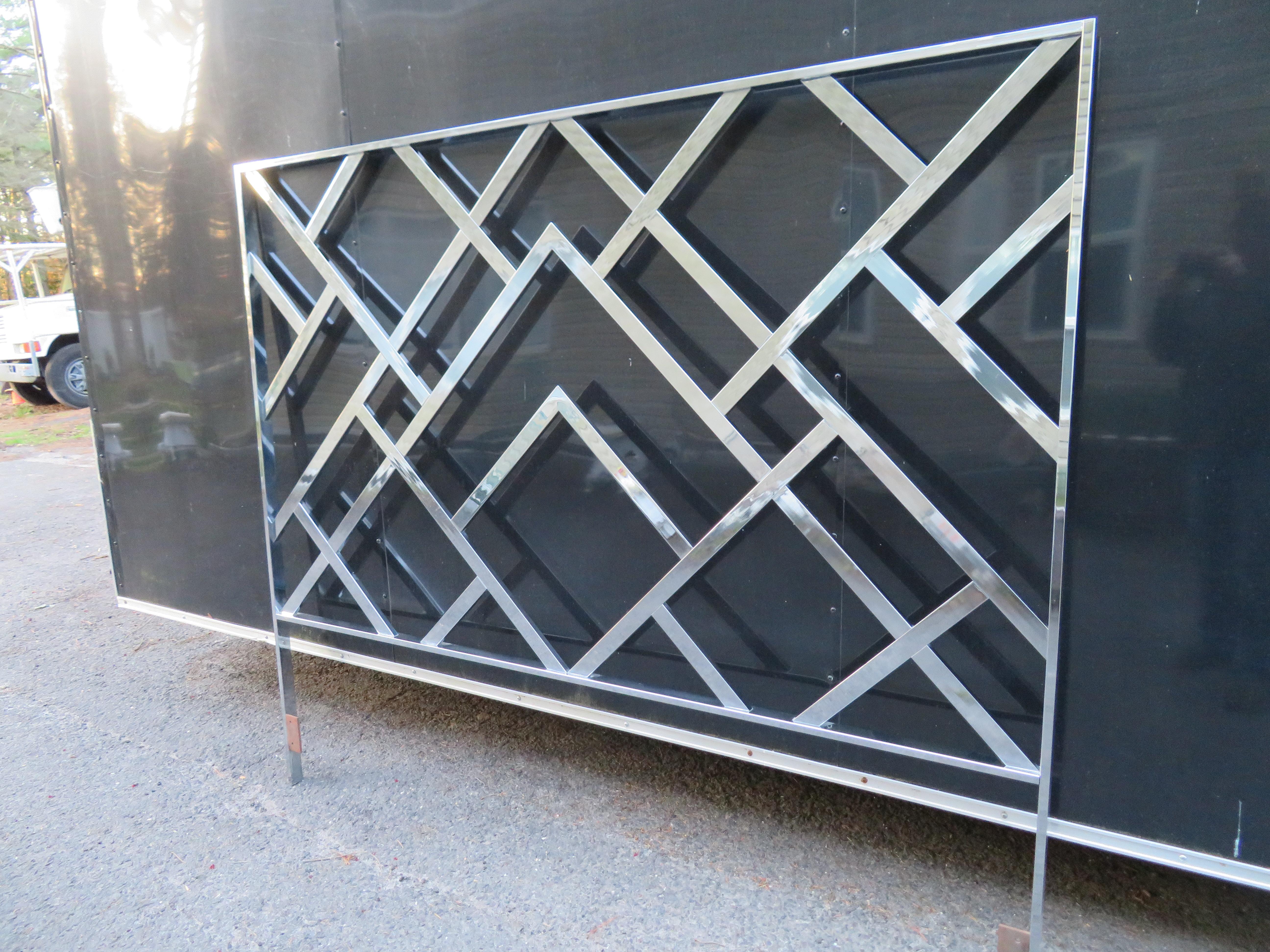 Add some glam to your bedroom with this amazing midcentury or chinoiserie style chrome king size headboard. This piece, which some attribute to Milo Baughman DIA features a mirror finish chrome frame with a classic fretwork or lattice design. It is