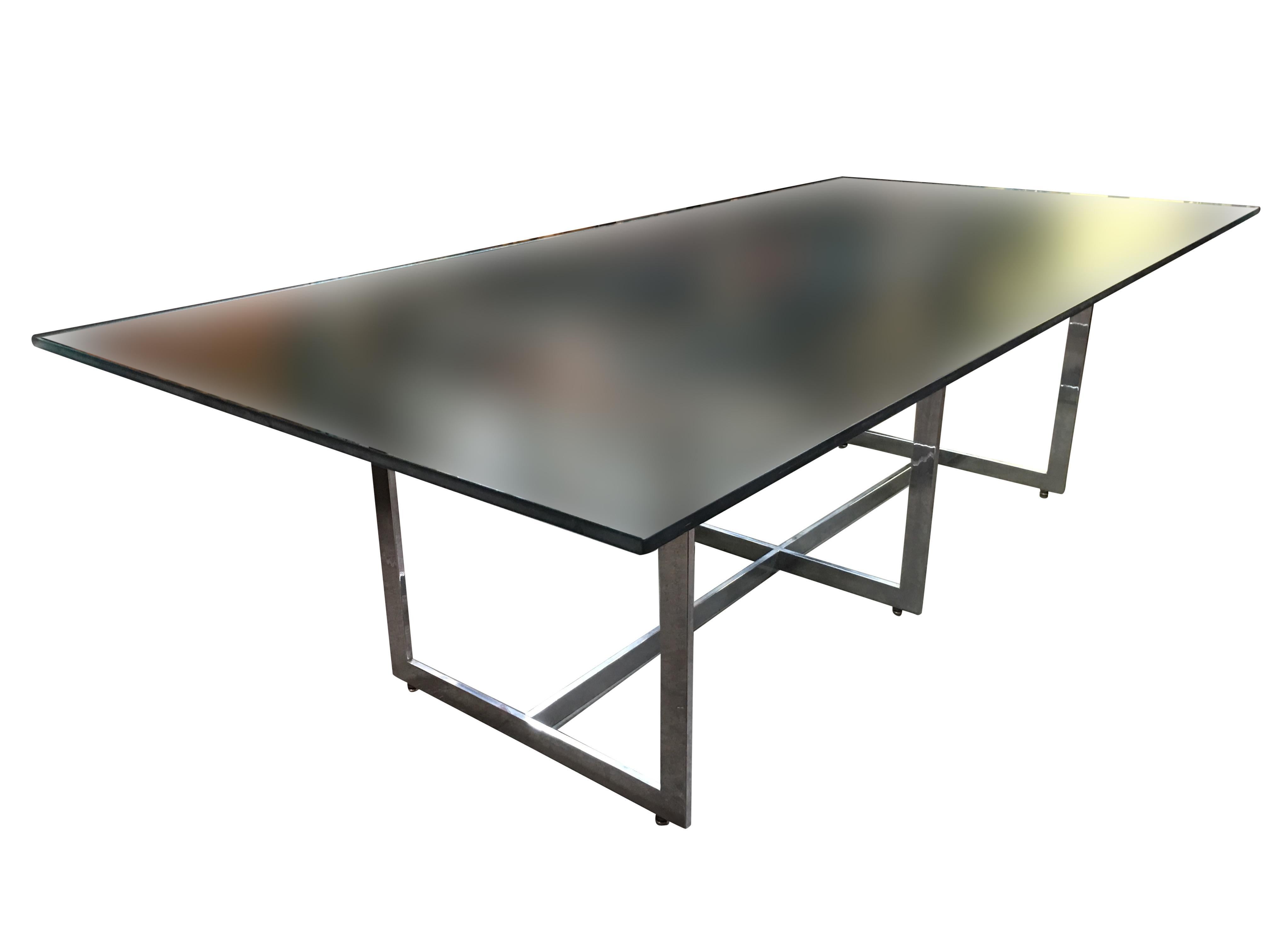 Large 8 person glass dining room table with a sculptural chrome base in the style Milo Baughman. The dining table comes with a 3/4