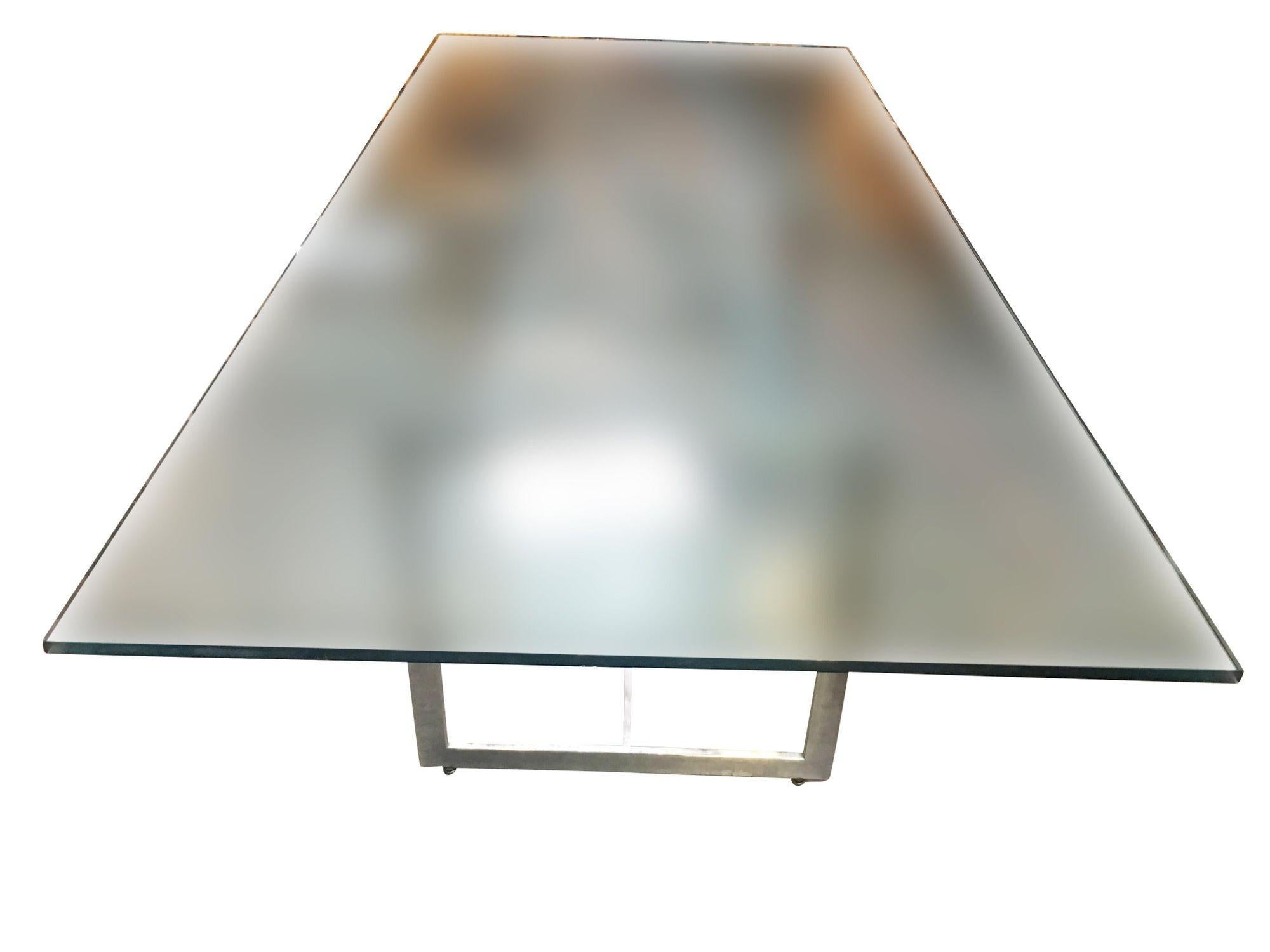 Large 8 person glass dining room table with a sculptural chrome base in the style Milo Baughman. The dining table comes with a 3/4