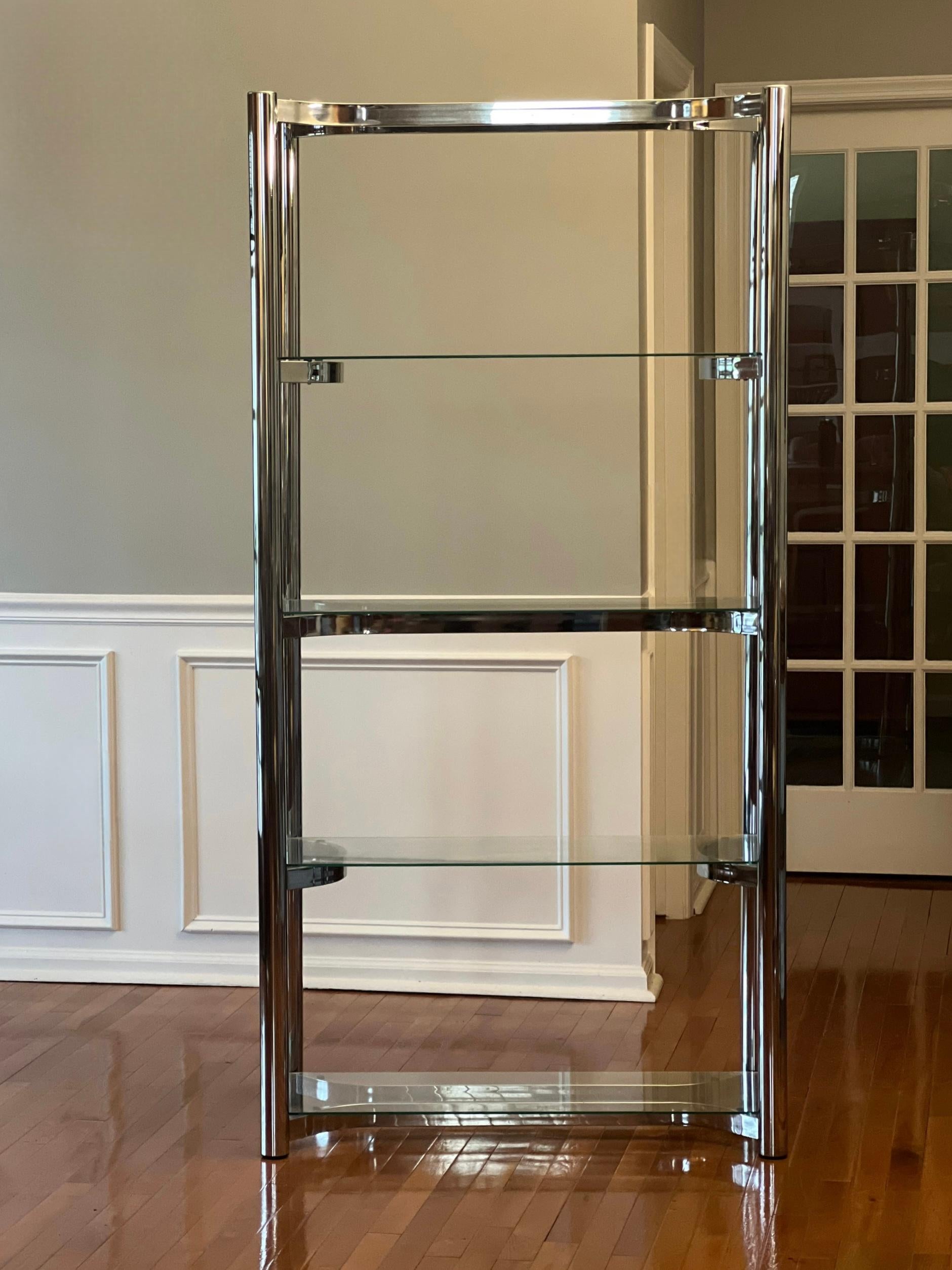 1970s chrome etagere with four glass shelves in the manner of Milo Baughman. 

The flat bar shelf supports are set in an alternating curved pattern giving it a sleek uniqueness and nicely complement the thick tubular chrome verticals. The top is