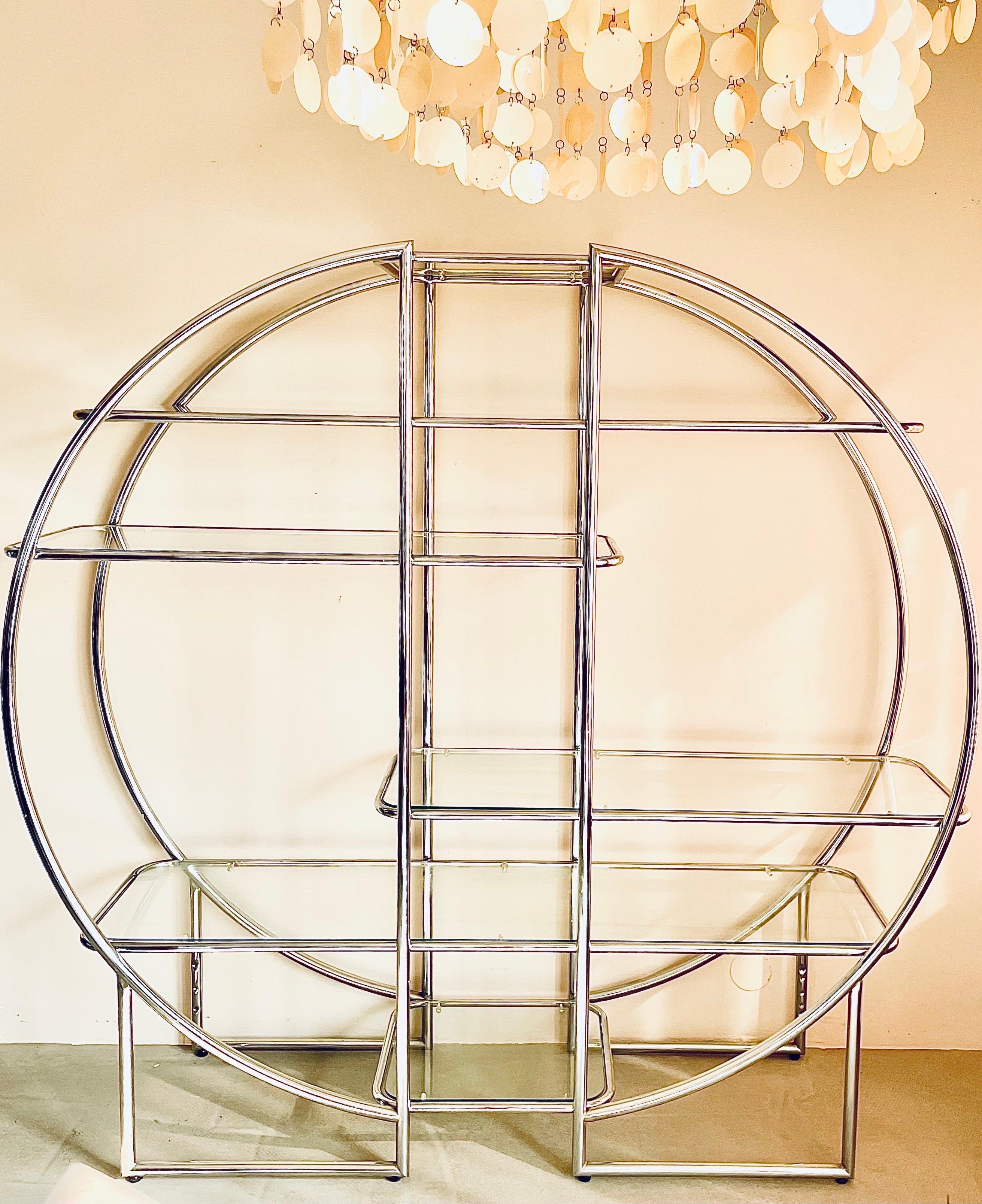 Wonderful chic round étagère, room divider, vitrine or book case in the manner of Milo Baughman. It has a beautiful circular shape, with six glass shelves in different sizes; the glass is in excellent condition, no scratches, no chips or any other