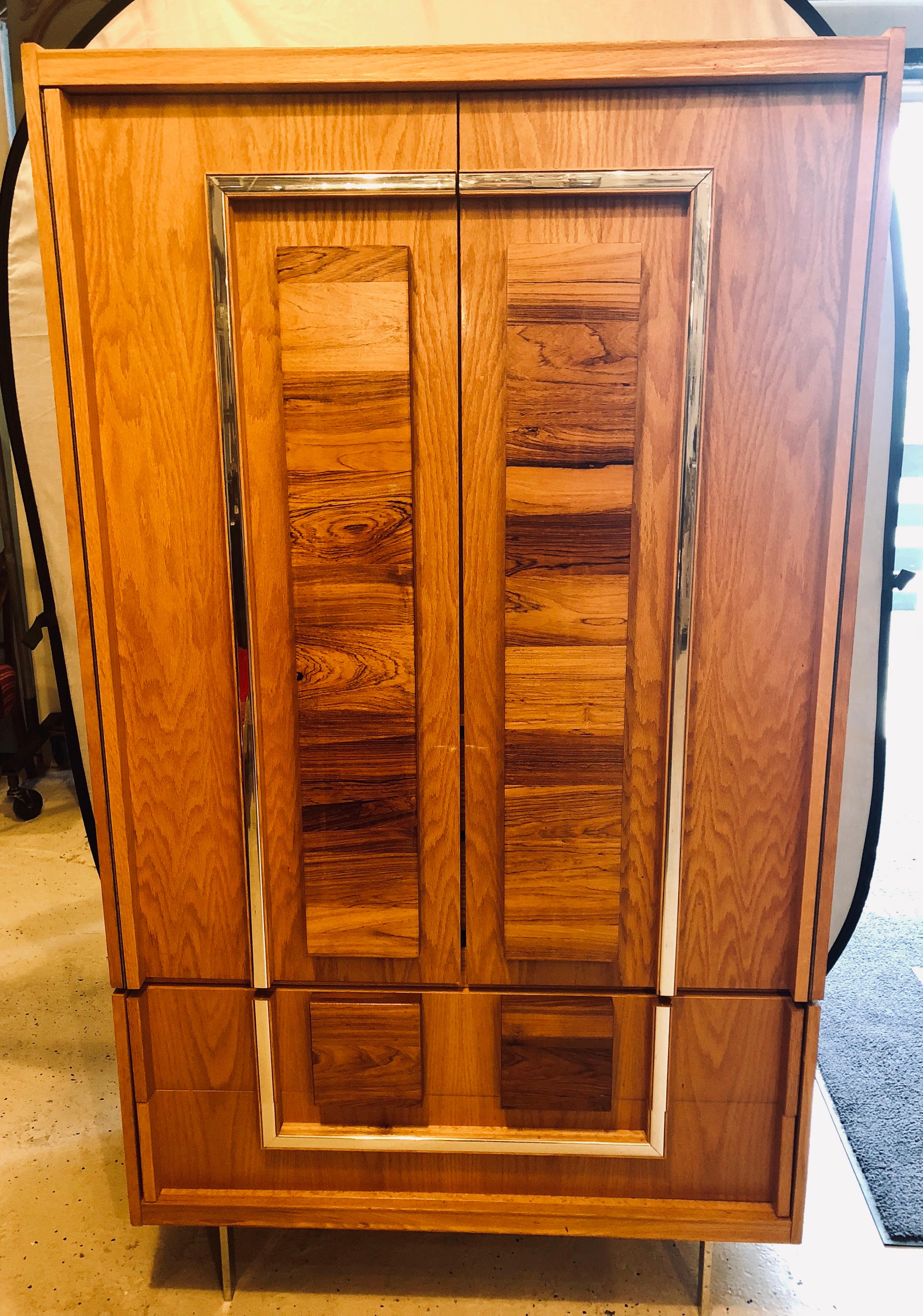 Stunning Mid-Century Modern two-piece custom quality Hi chest or armoire deigned after Milo Baughman. This fine wood and chrome chest is marked Made In Canada having rosewood and oak veneer accents on front supported by flat bar chrome legs. Two