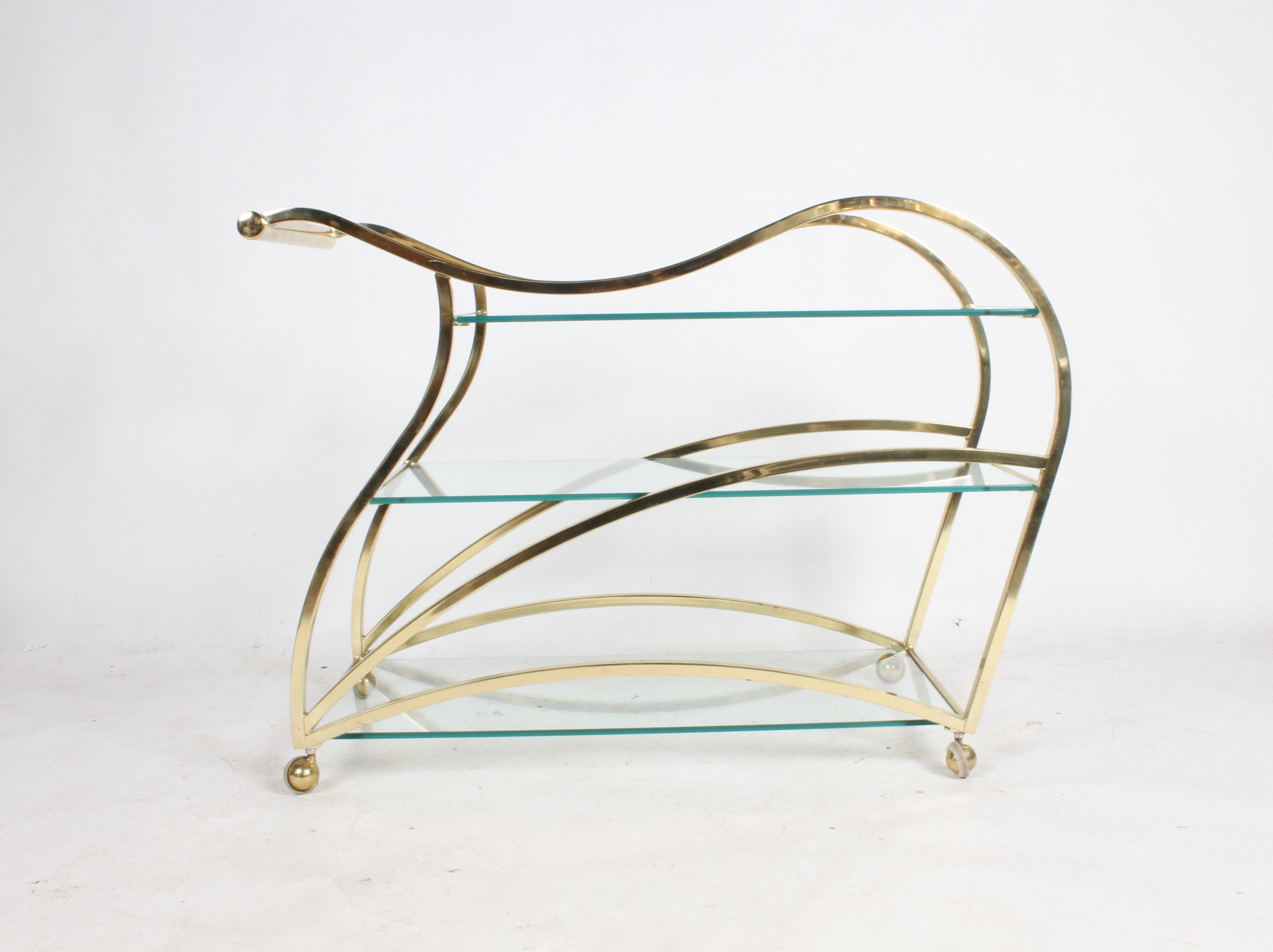 DIA or Design Institute of America designed brass sculptural bar cart, a true piece of art. This rarely seen cart is in very nice original condition. Minor wear to brass on handles, few light scratches to glass, light patina. In the style of Milo