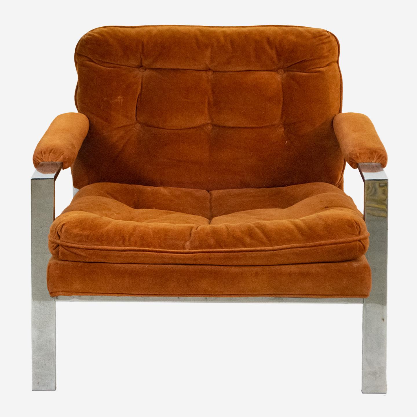 Vintage Milo Baughman style flat bar lounge armchair featuring the iconic flat bar chrome frame, upholstered cushions and armrests in rust velvet fabric. Timeless clean lines with its modern look make this piece sought after by many. The fabric is
