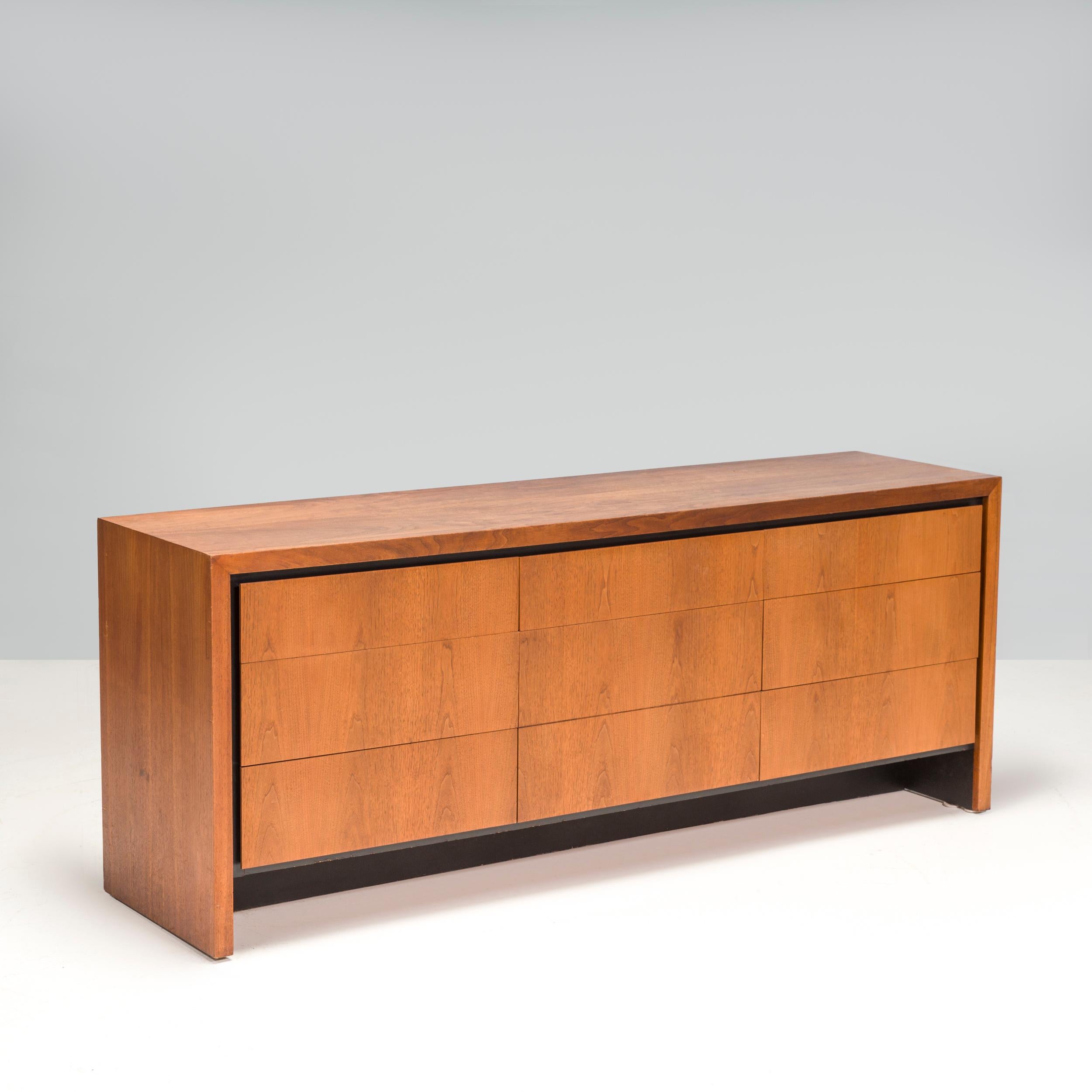 A beautiful wooden sideboard or credenza in the style of American designer Milo Baughman (1923-2003). Great for storage, this sideboard consists of 6 large drawers in walnut wood grain with a black laminate trim. 

An incredibly versatile piece,